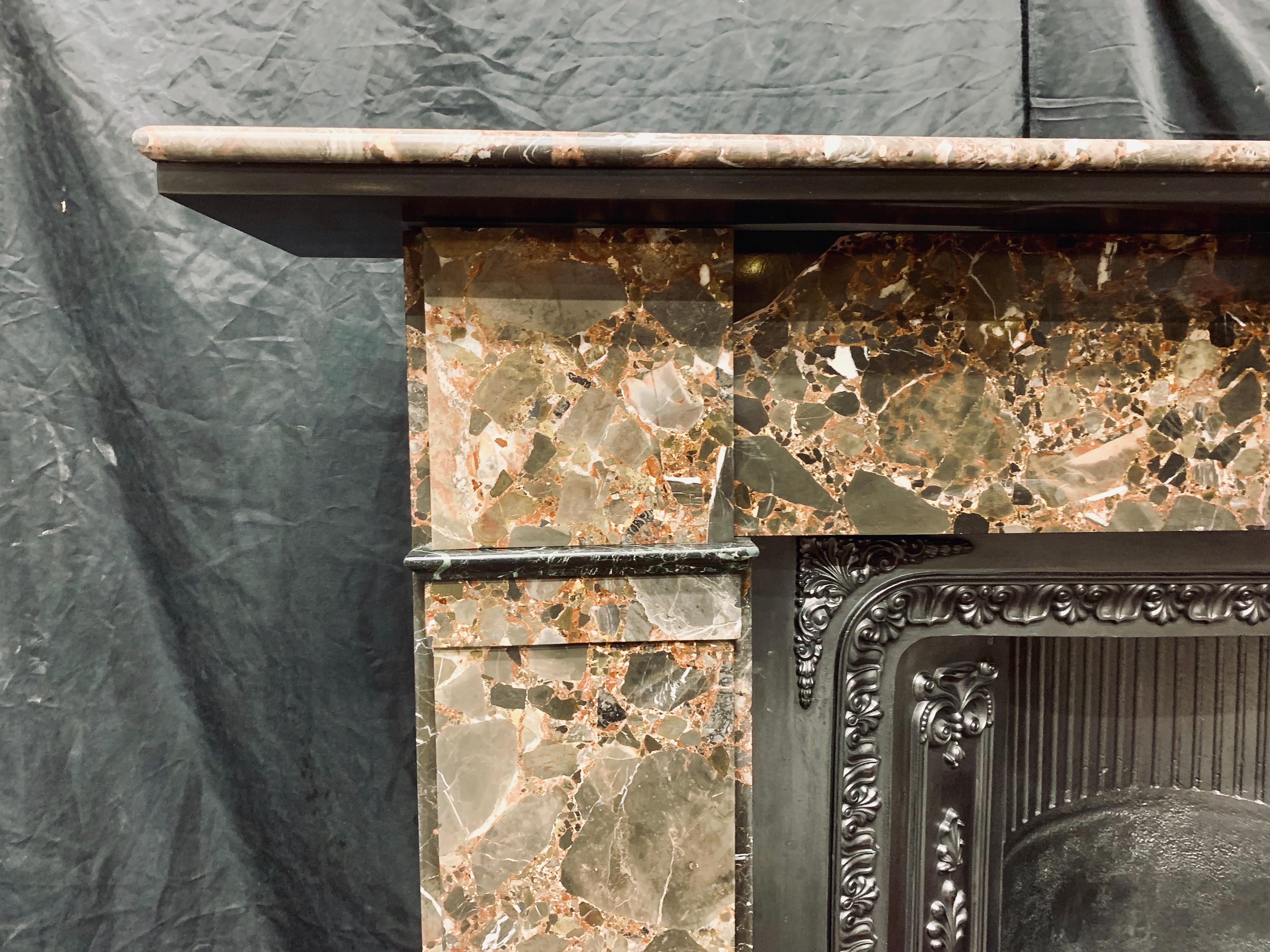 A large and splendid 19th century Victorian rare Breccia marble fireplace surround, showing many beautiful colors in this harlequin Breccia, a large and generous bullnose shelf with a secondary Belgian Black marble under shelf sits above a deep