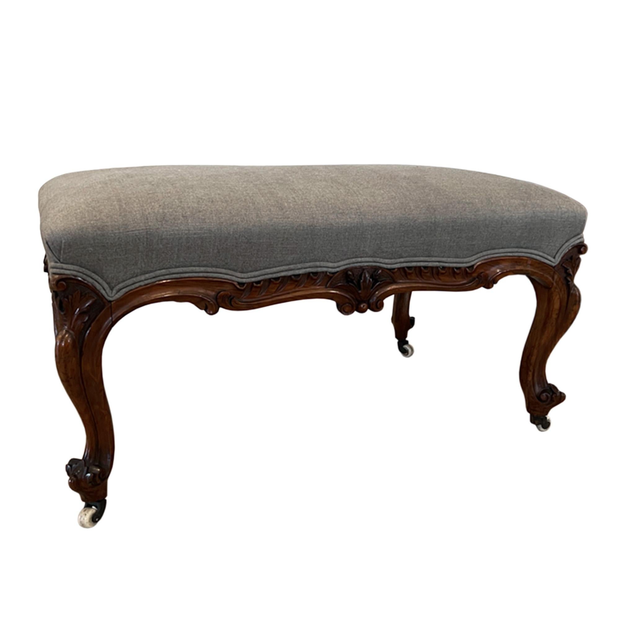 This large upholstered foot stool was made in England in the 19th century. It is beatifully carved all the way around and sits on the original ceramic castors. 

We have reupholstered this piece in Mark Alexander linen.