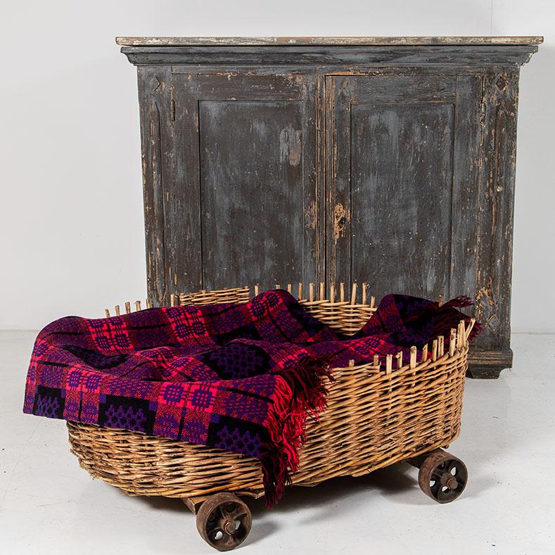 An old mill basket from the famous 'Tonedale Mill' in Somerset.  Originally this would have had tall sides for transporting wool, it has two small iron axles with cast iron wheels.
Would make a lovely dog bed or log basket as shown.  At 3ft wide it