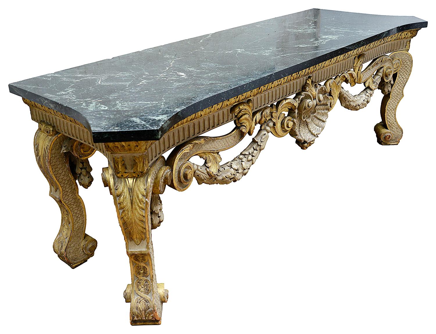 A wonderfully impressive large 19th century marble topped William Kent style console table, having Ivory and gilded decoration, carved acorn swag, sea shell and scrolling foliate decoration, raised on carved cabriole legs with fish scale and carved