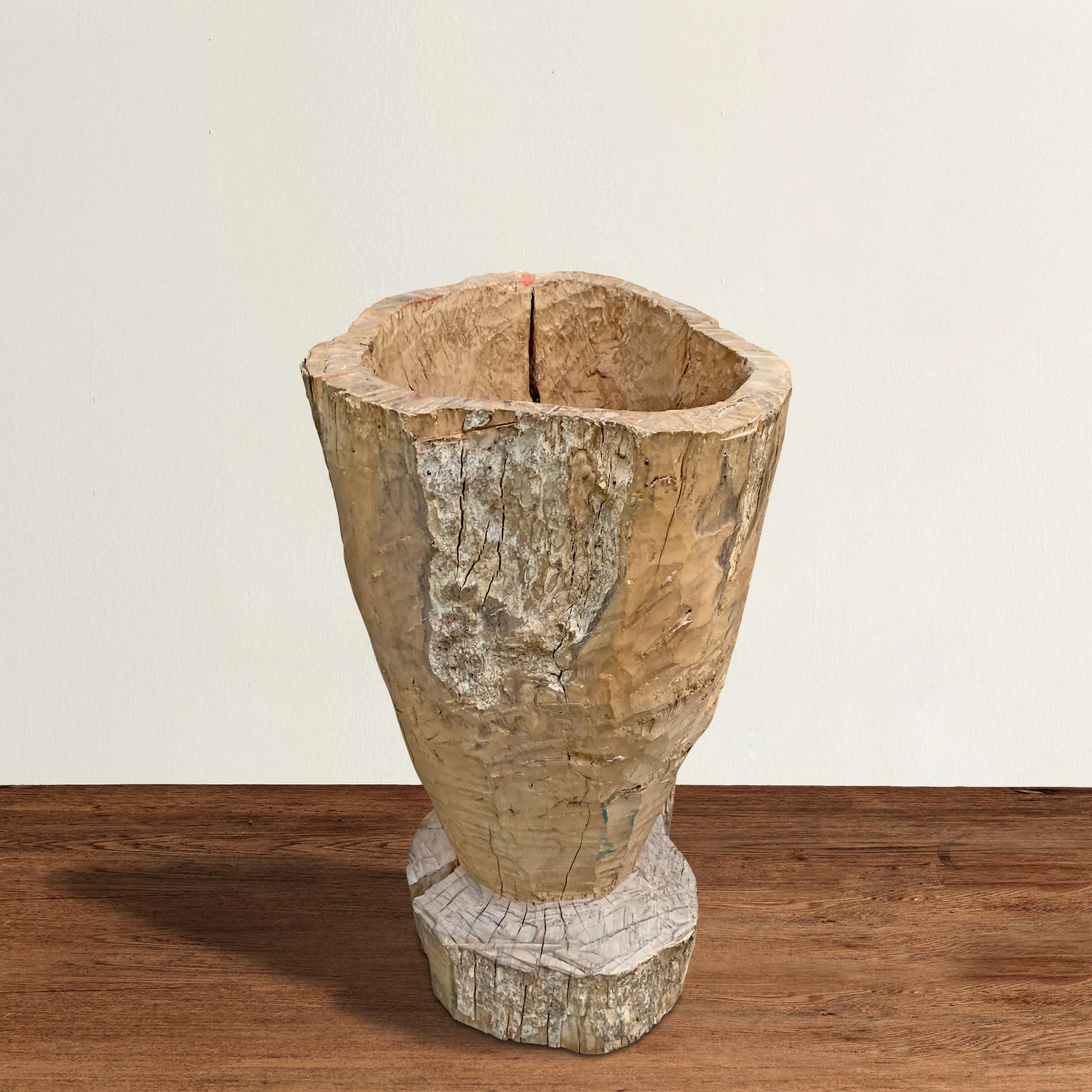 A large 19th century Central American wooden mortar with a beautifully hand-hewn texture and a well worn finish. Mortars like these were used to crush grains, spices, herbs, and other foodstuffs, but today it's perfect for holding logs next to your