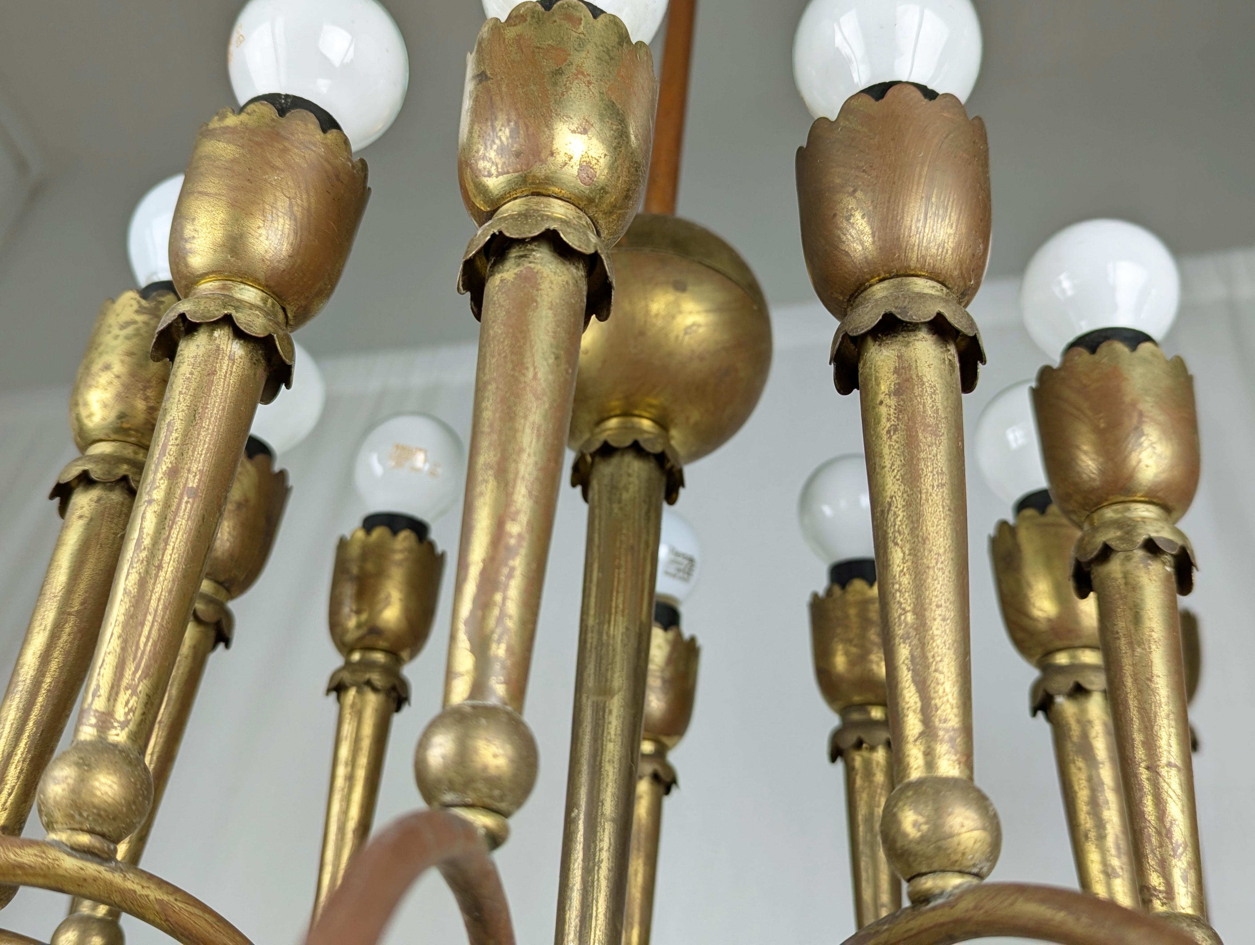 Lampadario vintage a 20 luci realizzato in ottone negli anni '40. Il lampadario è dotato di 10 portalampade E27 per l'anello esterno di luci e di 10 portalampade E14 per l'anello interno.
Buono  condizioni vintage: visibile patina di ossidazione
