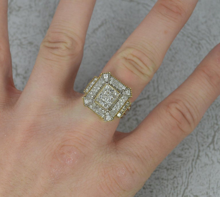 A superb 9ct gold and diamond ring.
Solid 9 carat yellow gold example.
Designed with a 3x4 princess cut diamond cluster to centre. Surrounding are a further 52 smaller round cut diamonds. The shoulders then hold a further 4 princess cut diamonds and