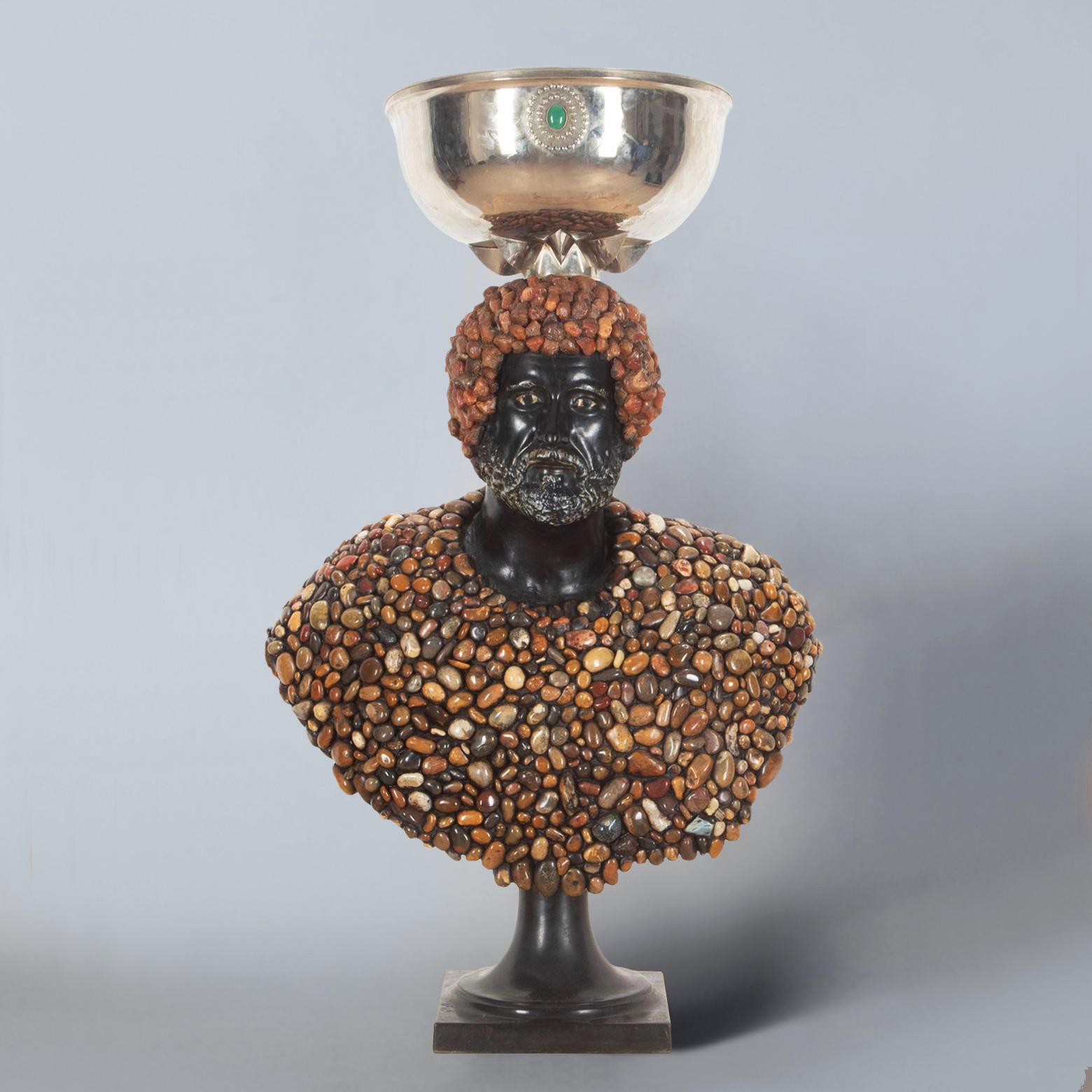 A rare and impressive J. Antony Redmile stone-encrusted, oversized classical bust, 1970s. 

Topped with nickel silver jardiniere (that can easily be removed), centred with a carbochon stone. The torso is encrusted with highly polished multicoloured