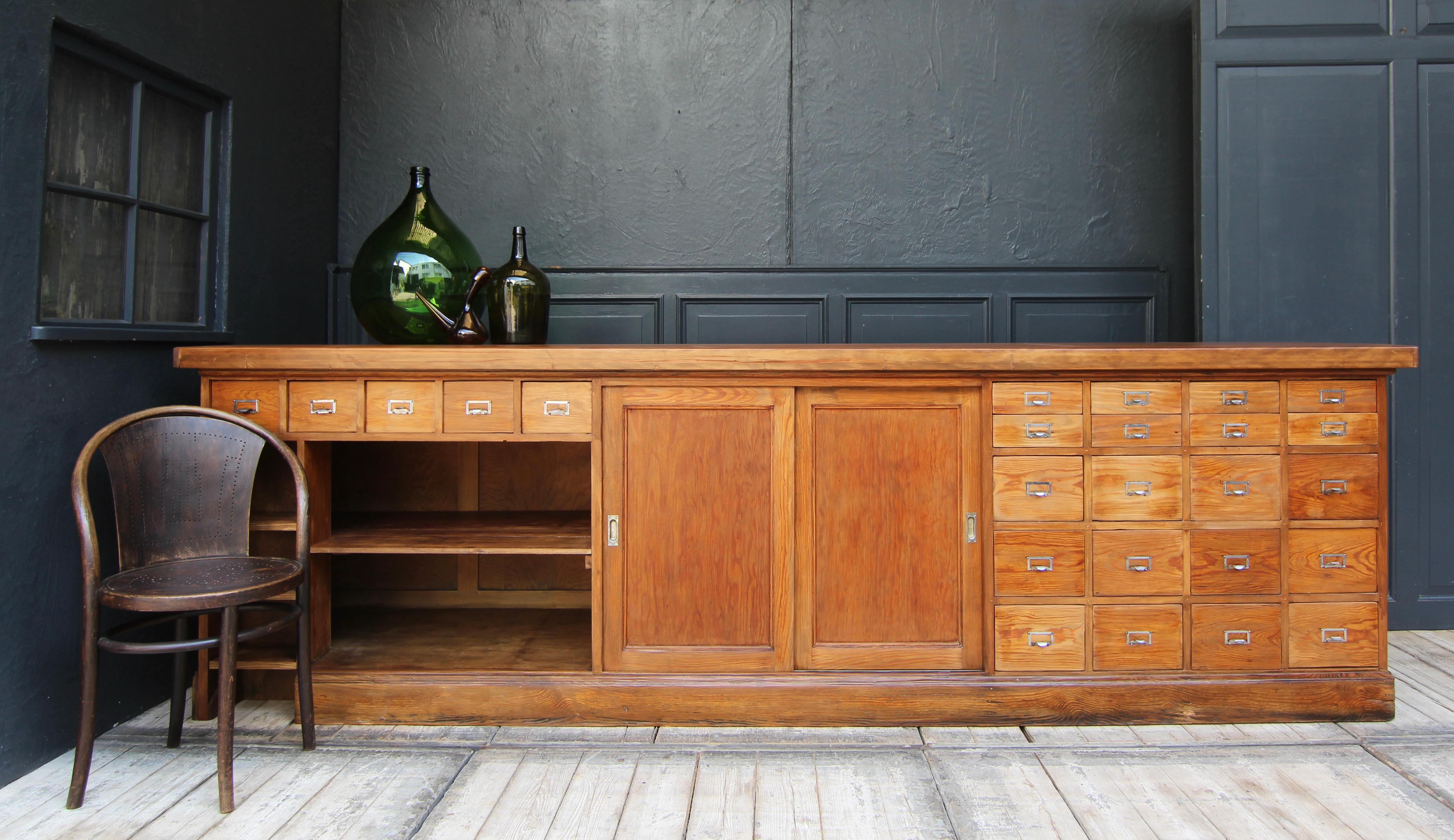 A large freestanding shop counter from a pharmacy. 1930`s/ 1940`s. Solidly crafted in pitch pine. 

Ideal for use as a counter, product display unit or kitchen island.

 
Three-sided panelled pine body (pitch pine) on a rectangular base with a