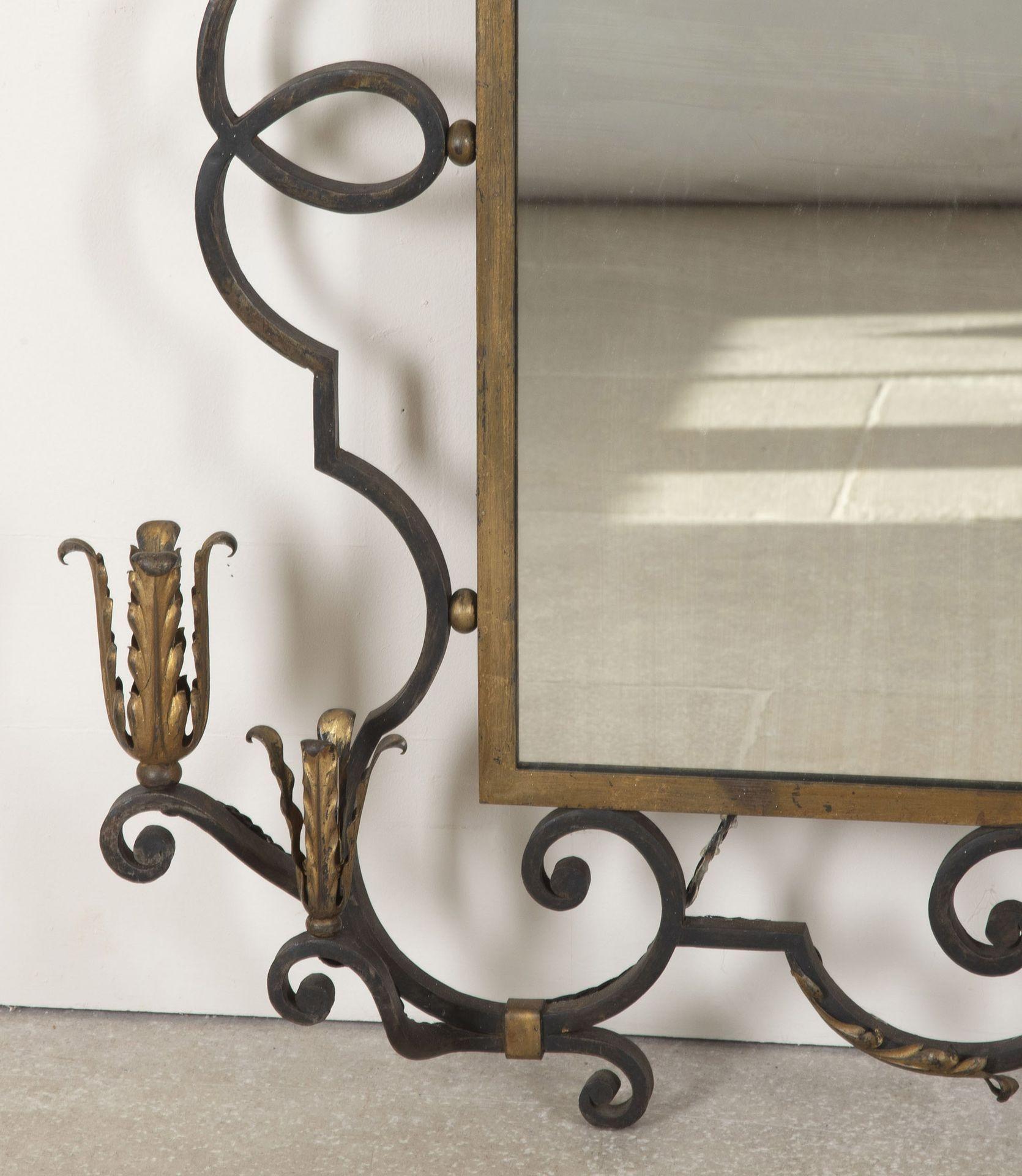 Grande e imponente specchio francese di fine Art Decor con decorazione in metallo dorato. 
La cornice presenta bordi a volute e frontone centrale alla maniera di Gilbert Poillerat. Circa 1940.