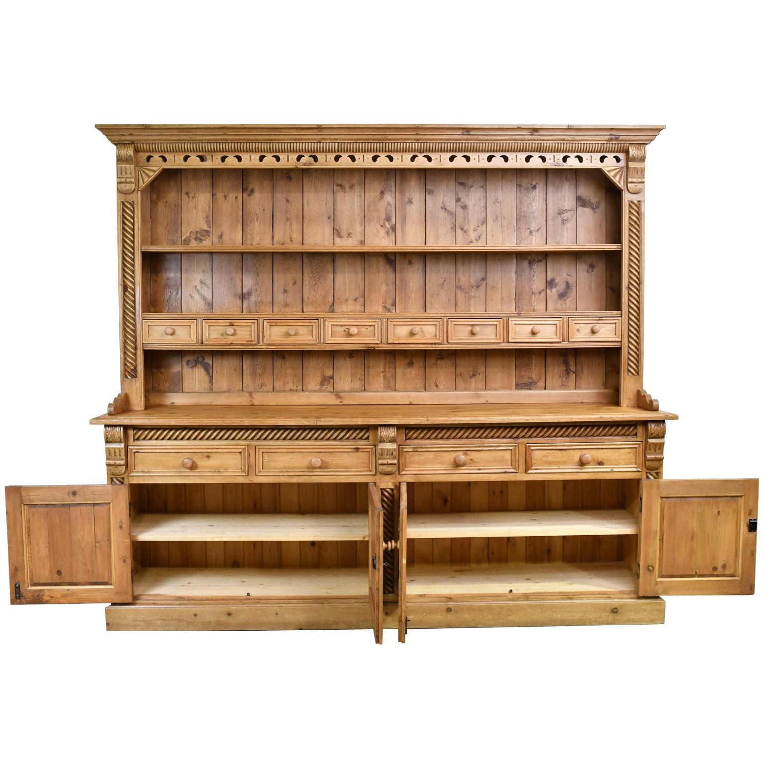 A well-made reproduction of a country pine Welsh or English Dresser with carved & turned embellishments that include cork-screw trim. Upper unit consists of open shelves for displaying dishes over a series of small drawers for utensils. The base