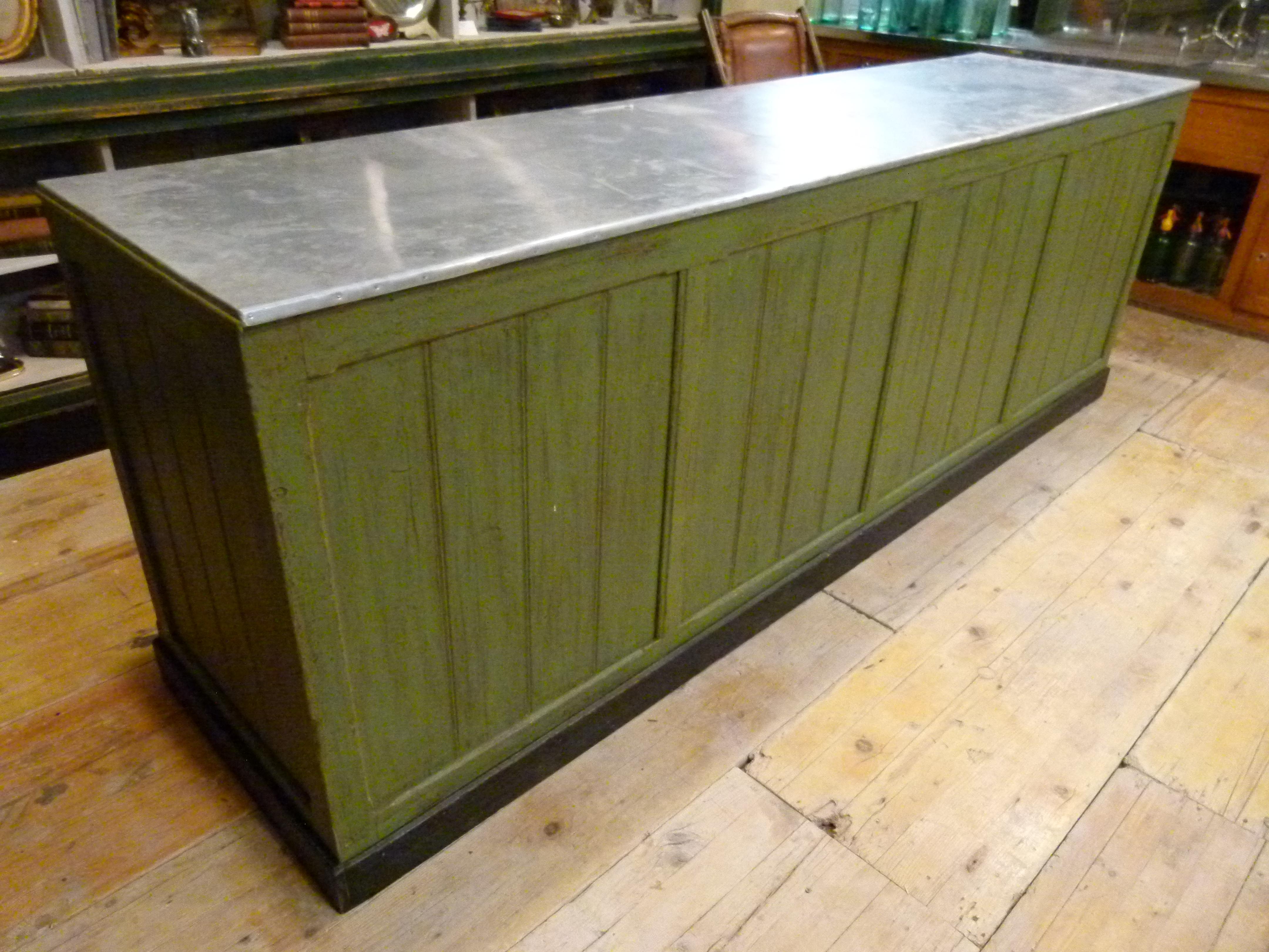 Large 20th century store counter made of hardwood and a zinc top. The wood has a green patina. 
The two colors green and zinc combine perfectly well  giving an elegant look to this piece




