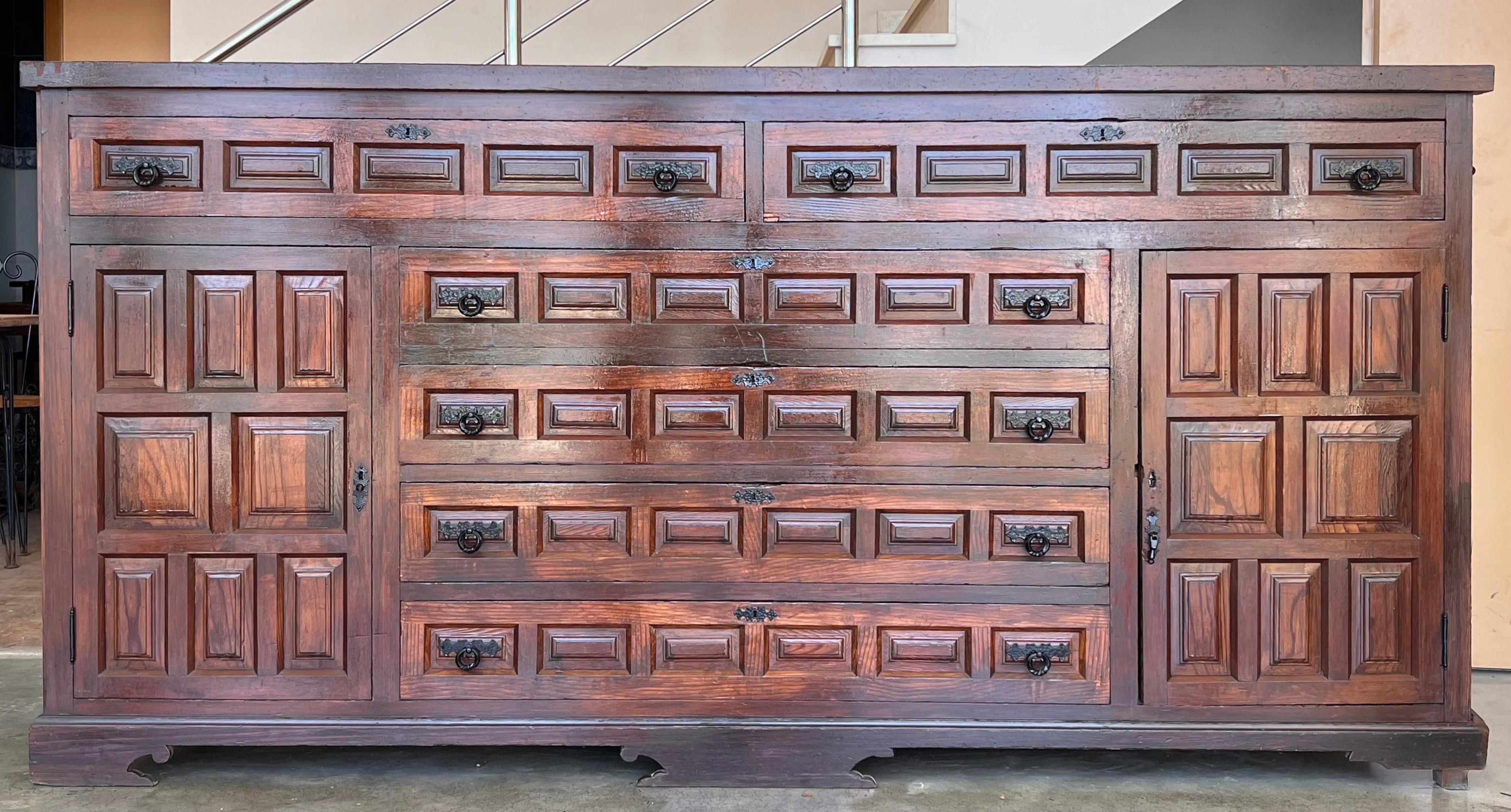 Coming from northern Spain, of an antique Church, this awesome church console was constructed of solid walnut, the rectangular top with molded edge above a shaped box housing four drawers over four doors, the doors faced with solid walnut and raised