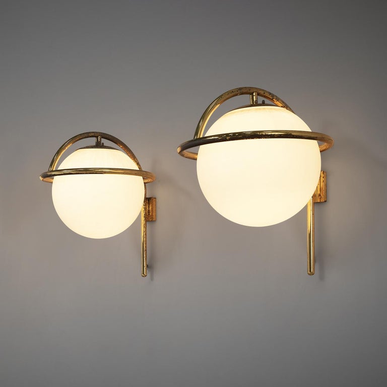Large wall lights, opaline glass, brass, Italy, 1960s

Elegant wall lamps in large size. With measurements of 70 x 57 cm (ca. 27 x 22 in.) this wall lamp has an impressive size. The white sphere rests in a patinated brass frame. The highly elegant