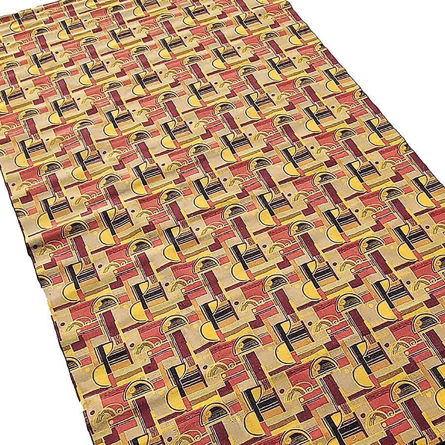 Large Art Deco style Area rug featuring a multicolored geometric streamline pattern with warm reds, browns yellows, and beige tones, much like those from Edward Fields. This rug is flooring taken from the RMS Queen Mary in the 1970s and made into a