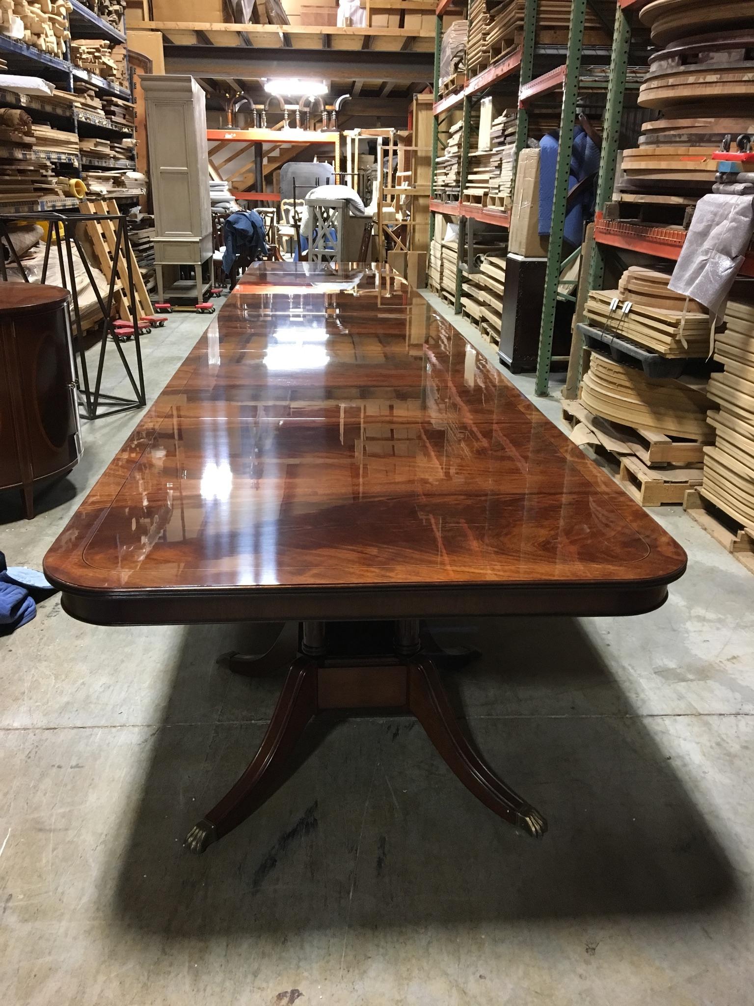 This is a made-to-order large traditional mahogany banquet/dining table made in the Leighton Hall shop. It features a field of slip-matched swirly crotch mahogany from west Africa with a contrasting border separated by an ebony and white maple Inlay