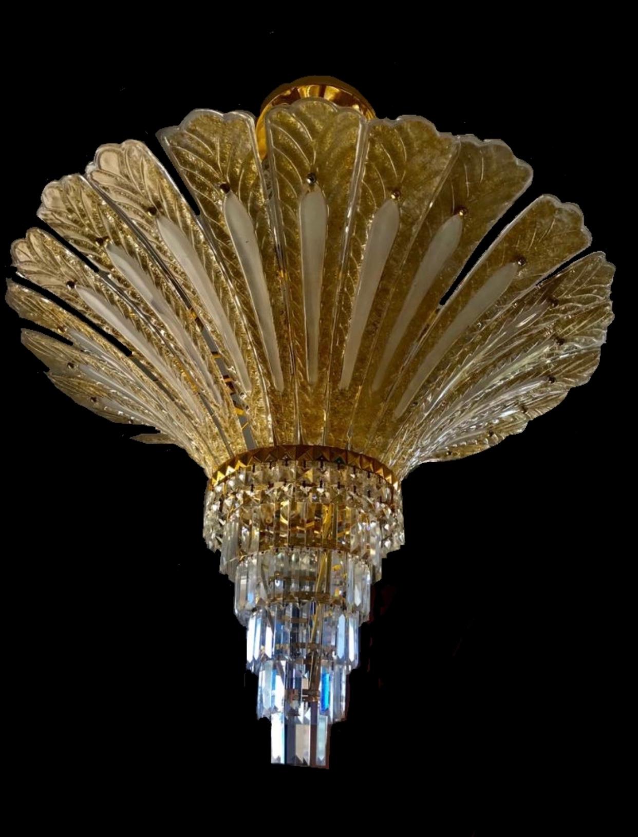 Un grand lustre de Murano en forme de feuille de palmier, en or moucheté 24 carats, avec des pièces de cristal facetté en forme de diamant baguette de taille princesse et suspendues à l'extrémité du lustre ( photo 3 ). La structure du lustre est en