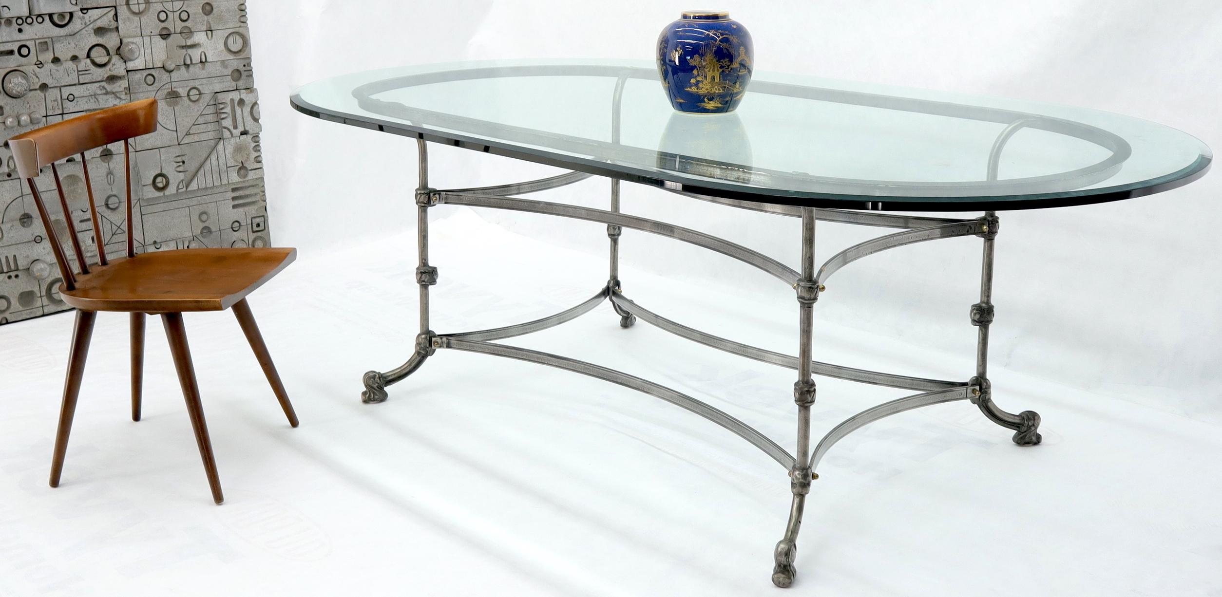 Decorative large forged metal base thick glass racetrack oval shape top dining conference table. Heavy and sturdy nice looking dining table.