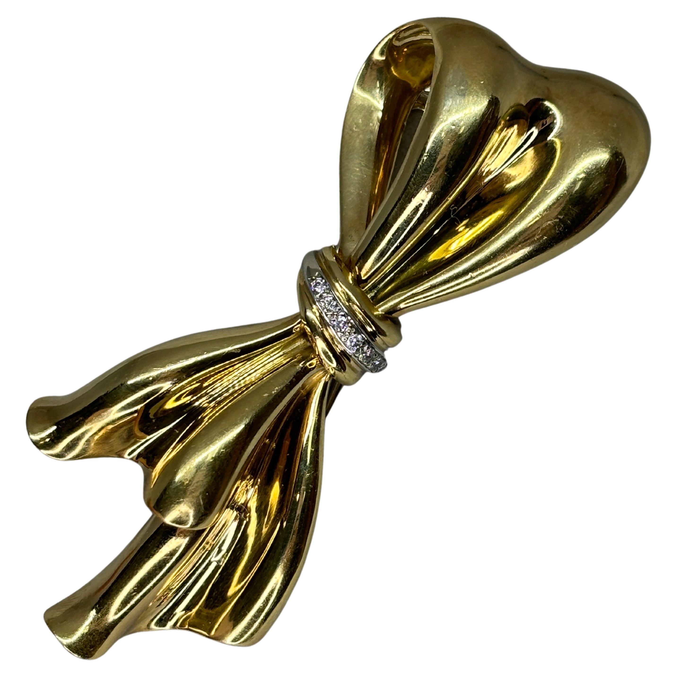 This beautiful 18k yellow gold diamond bow brooch showcases the beauty of fine materials and craftsmanship. Its timeless design, combined with the intrinsic value of high polished gold and diamonds, makes it a cherished item for any jewelry