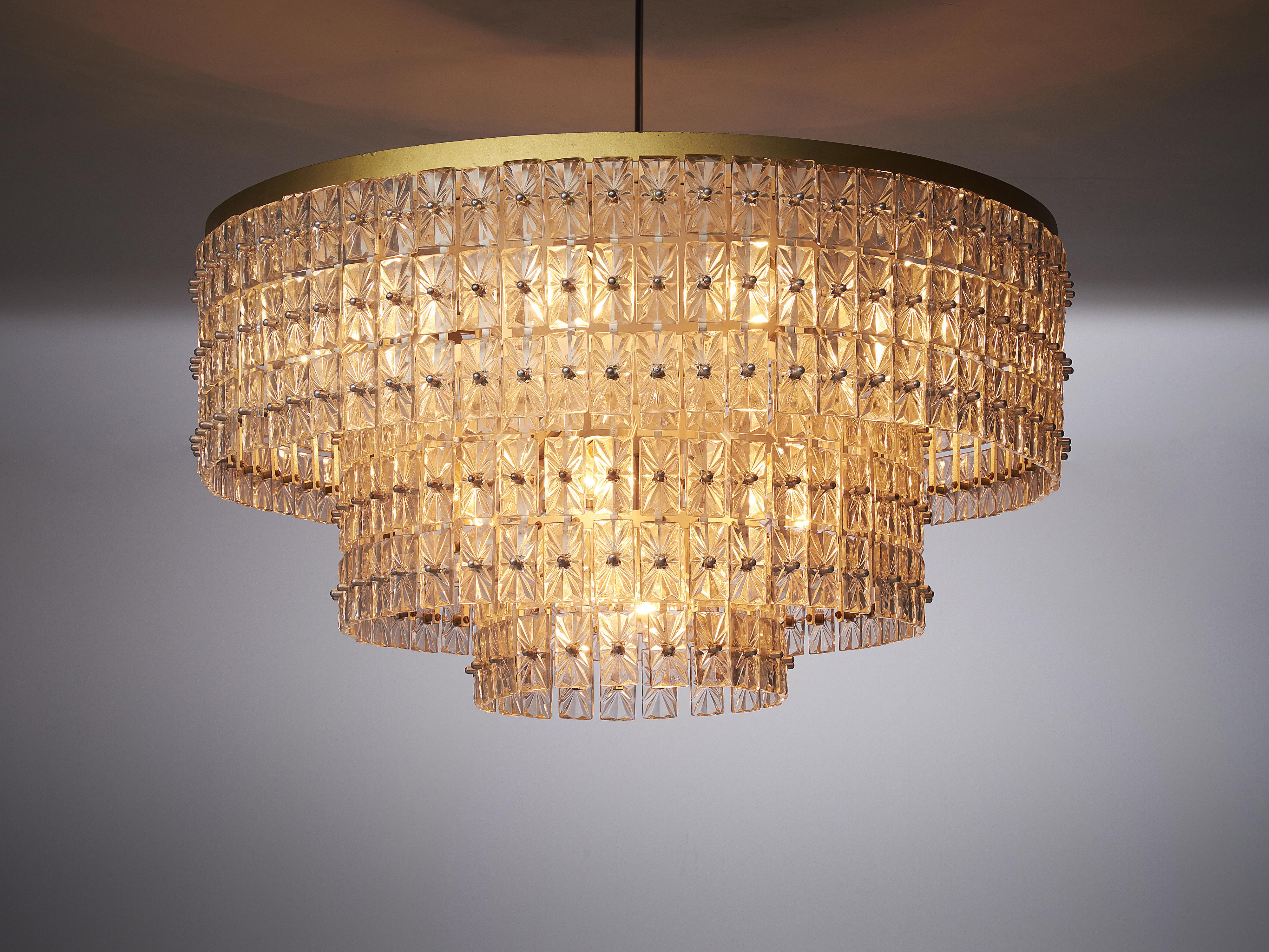 Extraordinary large chandelier in glass and brass, Austria, 1950s. Measure: 374 in.

This expressive chandelier has a round shape, built from a large amount of well detailed glass elements. They are mounted to a sincere construction and beautifully