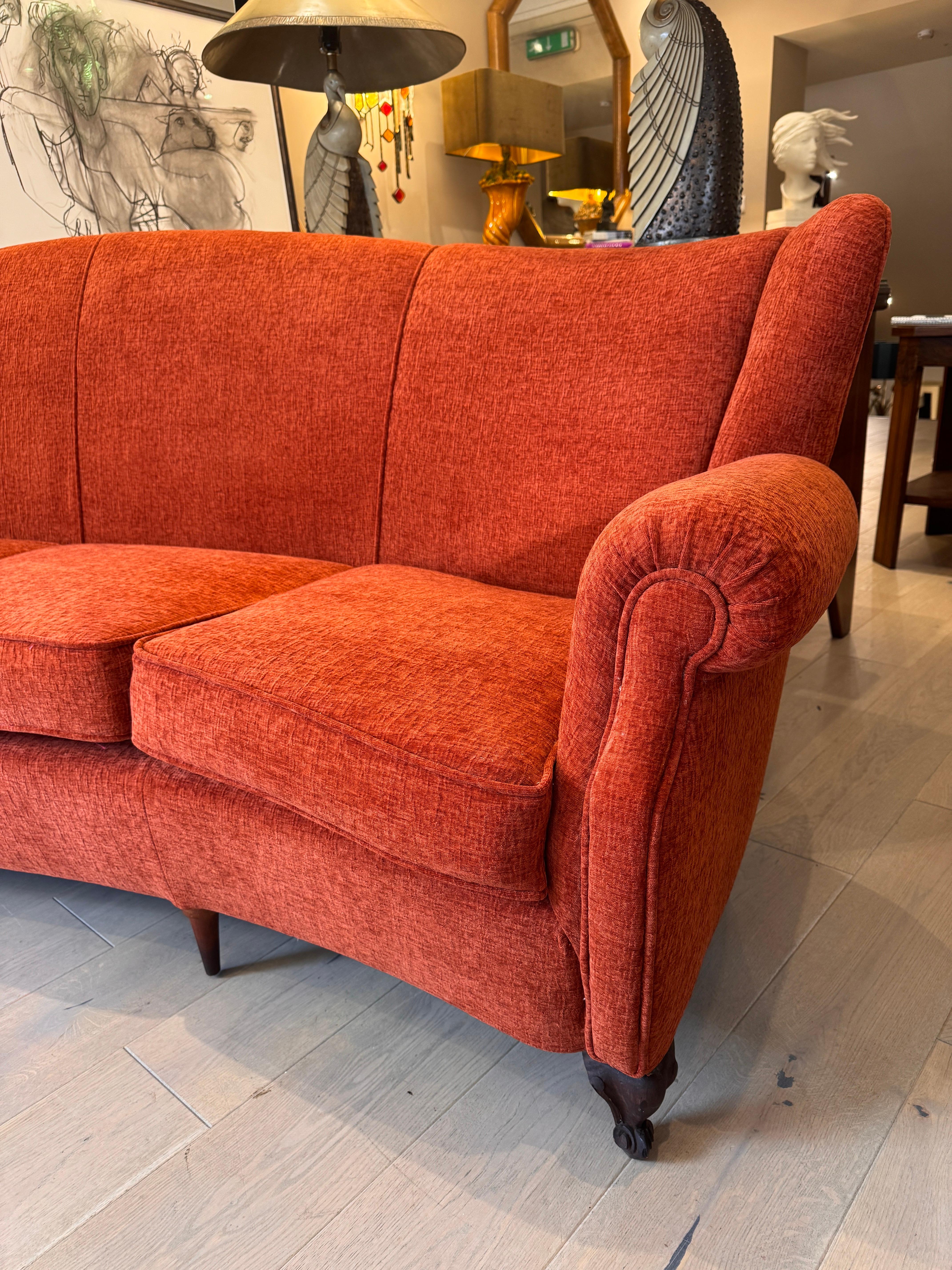 An exceptional large 4 seater semi circular wingback sofa newly upholstered in lush coral orange textured velvet by our Milanese mid century furniture specialist. A beautiful example of fine Italian design combining classic with modern lines . 

