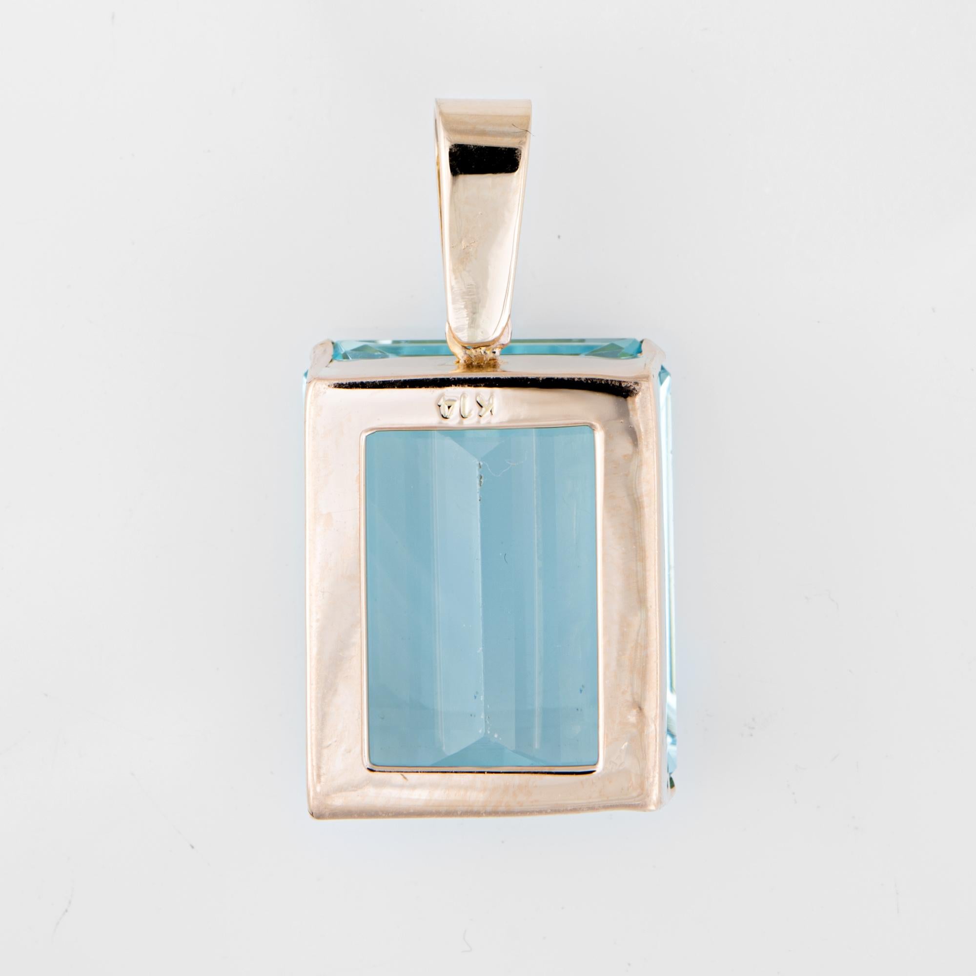 Finely detailed vintage large aquamarine pendant (circa 1950s to 1960s) crafted in 14k yellow gold.  

Emerald cut aquamarine measures 24mm x 19mm x 12.5mm (estimated at 40 carats). The aquamarine is in very good condition and free of cracks or