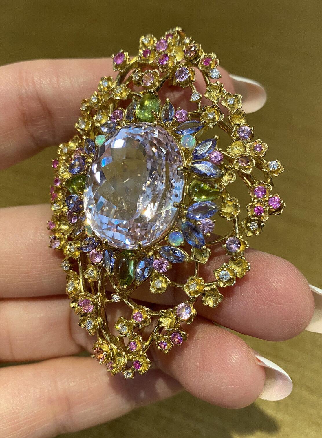 Kunzite and Multi-gems Diamond Pin / Brooch in 18k Yellow Gold

Kunzite and Multi-gems Diamond Brooch features a large Oval-shaped Kunzite weighing 41.63 carats, accented by pastel colored Tanzanite, Peridots, and Diamonds set in 18k Yellow