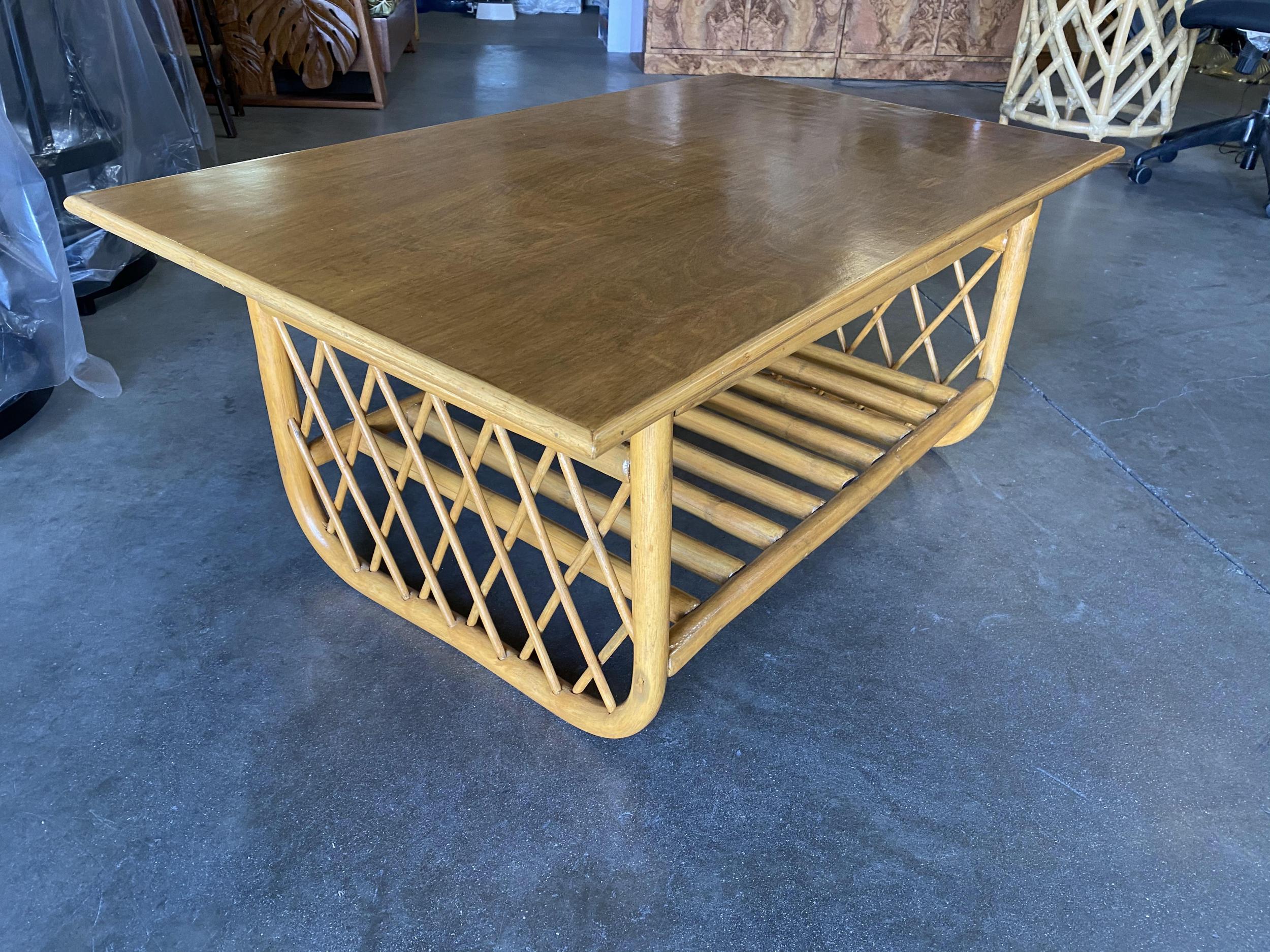 This minimal yet elegant coffee table features two side panels of diamond links with a U shaped based. The table features a mahogany top and a pole rattan lower tier for storage of magazines and devices.

Size: Large 41.5