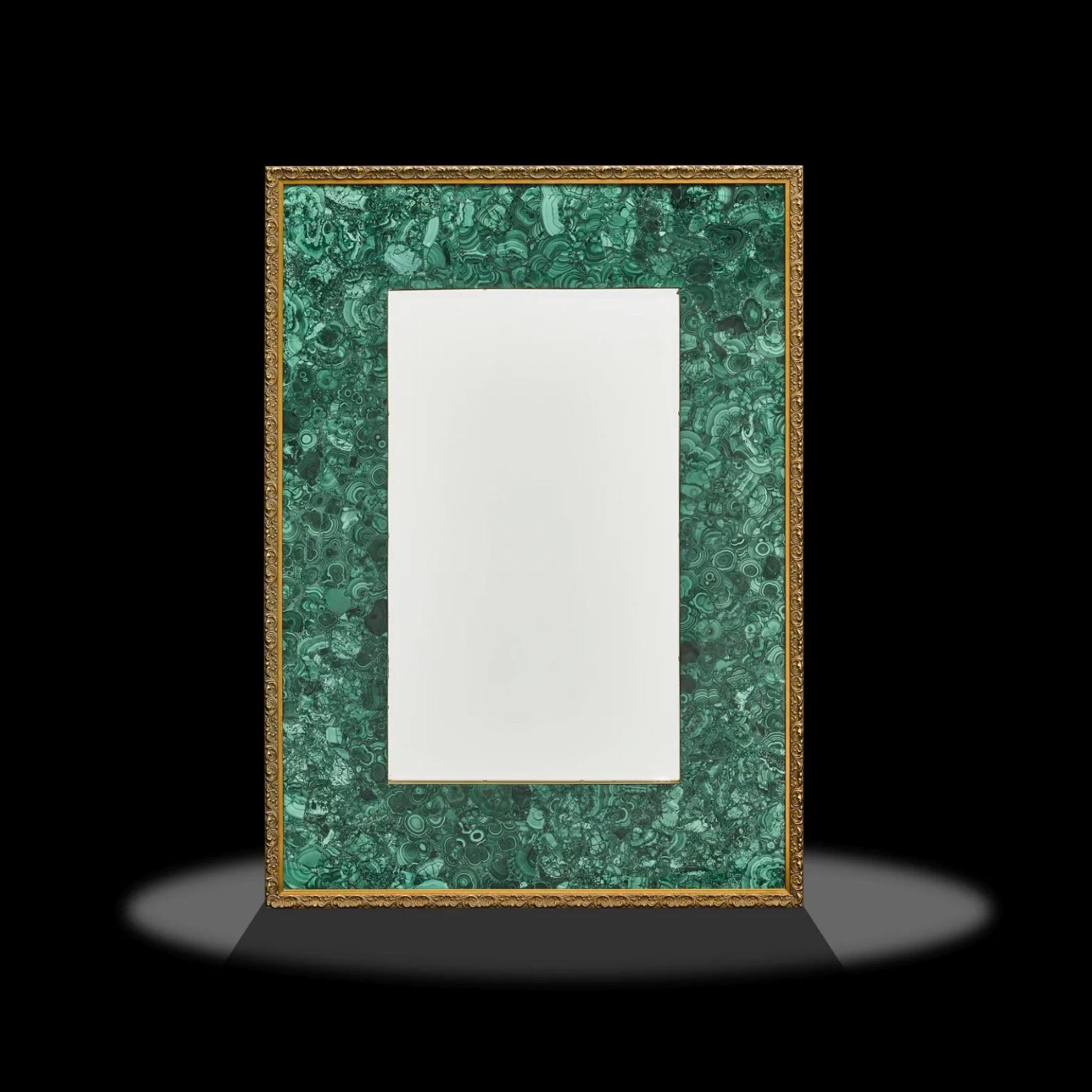 Si tratta di un incredibile specchio in malachite, molto pesante ed estremamente ben fatto, caratterizzato da un intarsio di malachite con bordi in ottone e una cornice in legno classicamente intagliata.  Il retro è dotato di una ferramenta