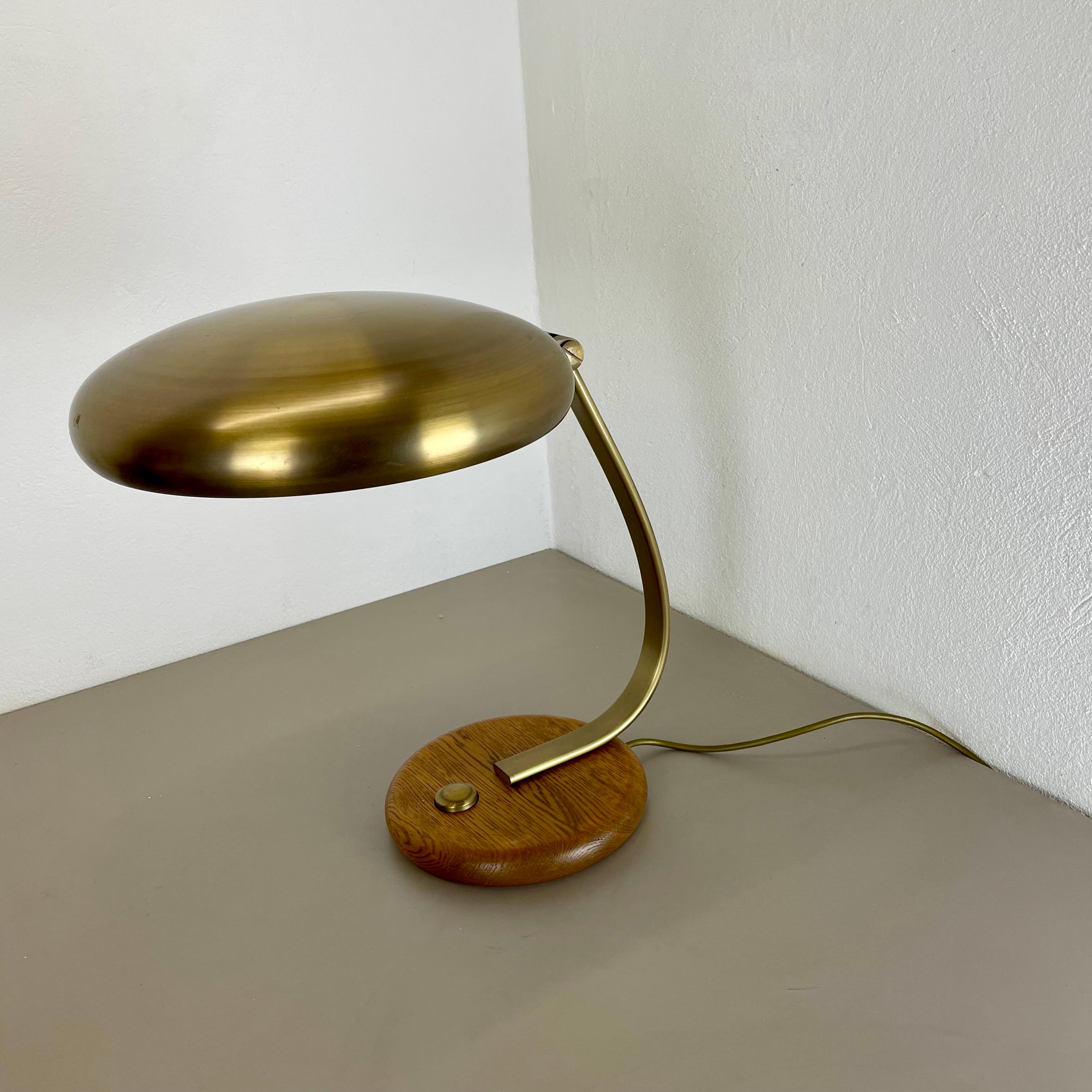 Article:

 table light


Producer:

Temde lights, Germany



Origin:

Germany



Age:

1970s




Original vintage table light made of brass and a wooden oak base element.   The object was designed and produced by TEMDE LIGHTS in Germany in the