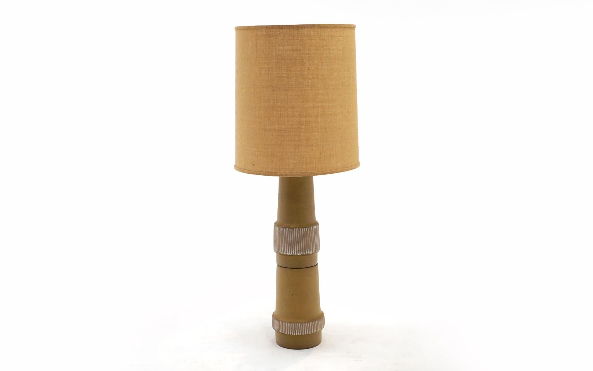 Large scale (almost four feet tall) ceramic table lamp designed by Gordon and Jane Martz for Marshall Studios. Colors are tan and white with sgraffito decoration. This fine and rare example retains the original shade and original walnut finial.