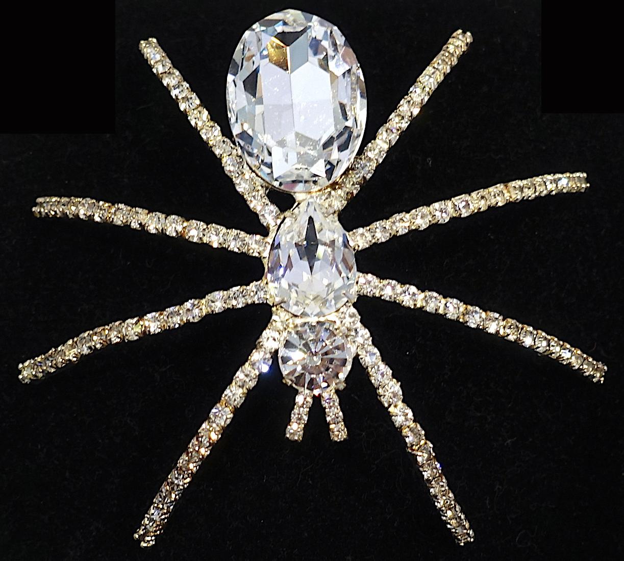 This large spider brooch has clear crystals on its legs and huge faceted crystals running on top its body. It is in a gold tone setting.  This brooch measures 4” x 3-1/2” and in excellent condition.