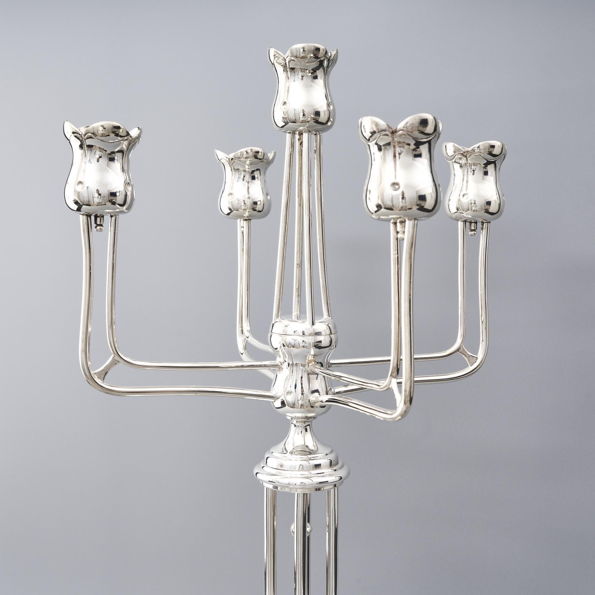 This is a large antique Austrian Secessionist period silver candelabrum by Emil Kadzik. The domed base with its central column and fins, five stems and stylised tulip-shaped flower candleholders, personify this era of design. 

This is a lovely