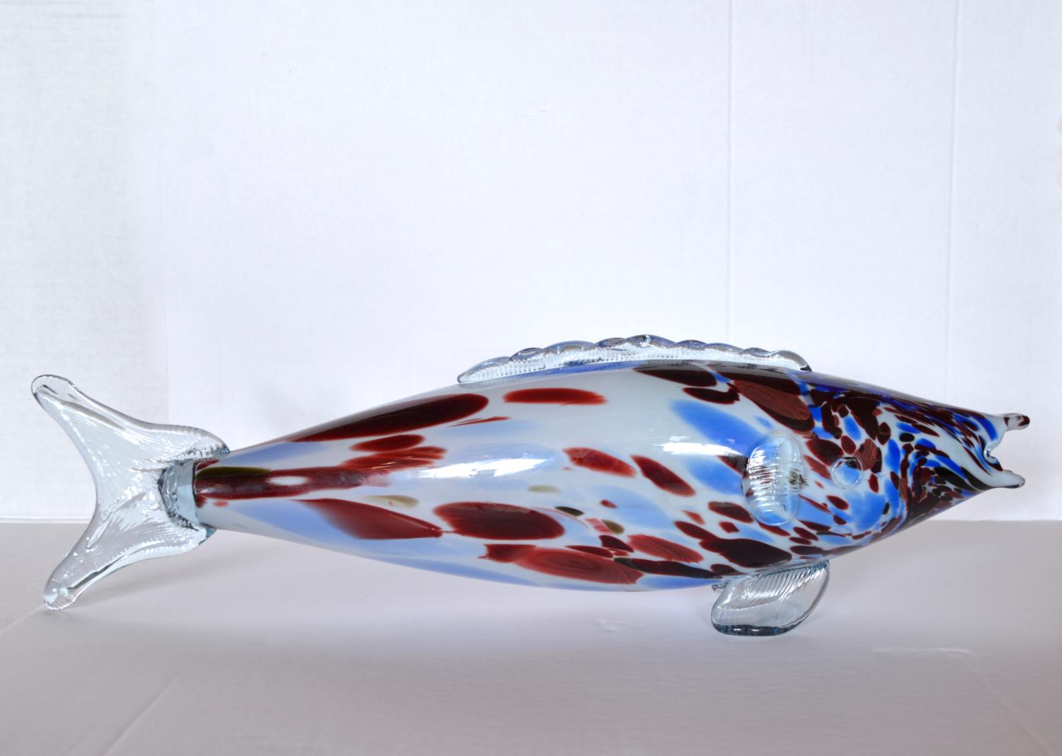 Debido a la naturaleza del soplado de vidrio, cada pez de Murano es individual, ¡y tenemos la suerte de poder ofrecer un gran pez de Murano que mide unos impresionantes 50 cm de longitud! El color principal es el azul pálido, con hermosas motas