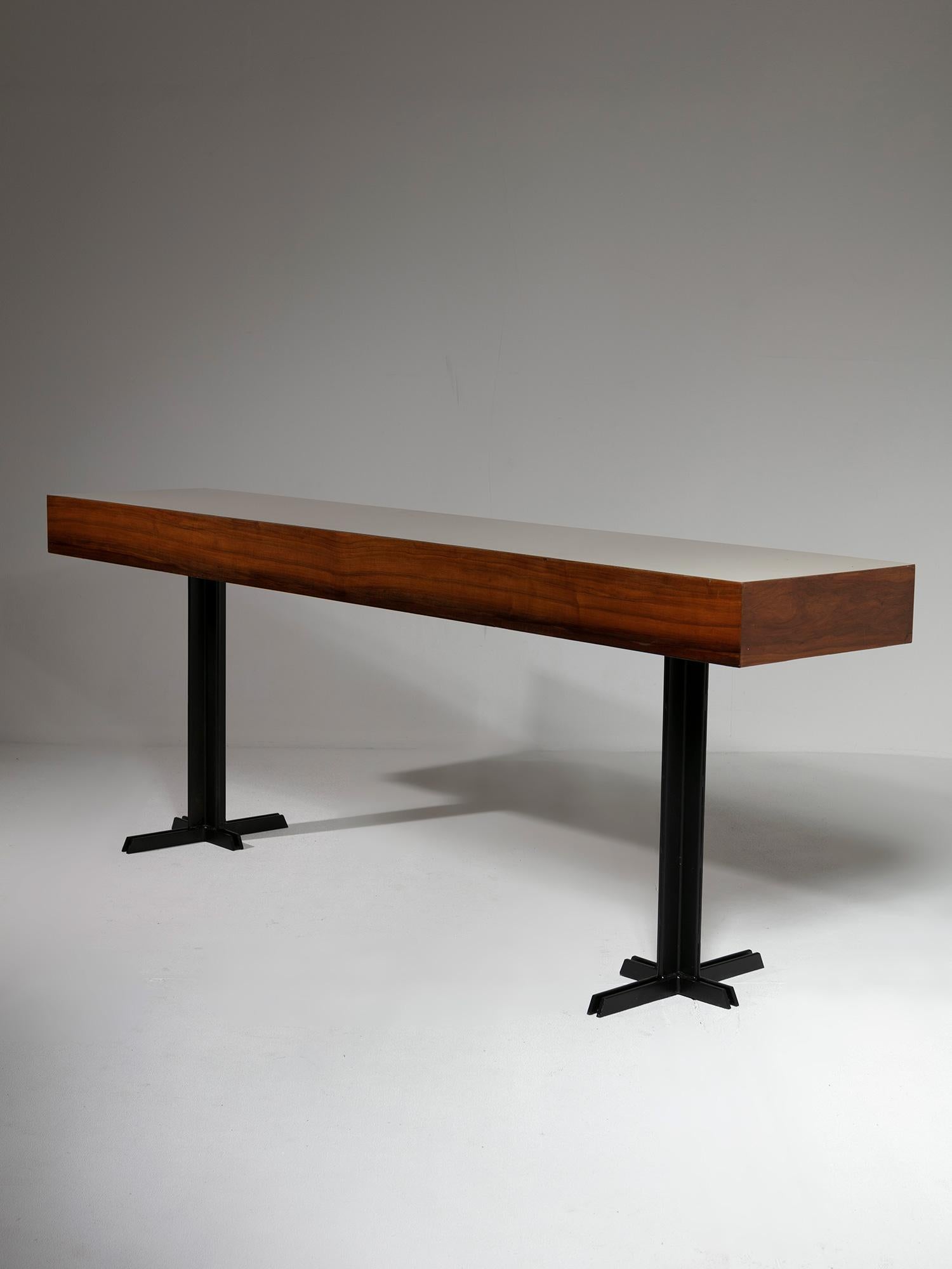 Large 50s console with black metal legs supporting a thick wood element with formica top.