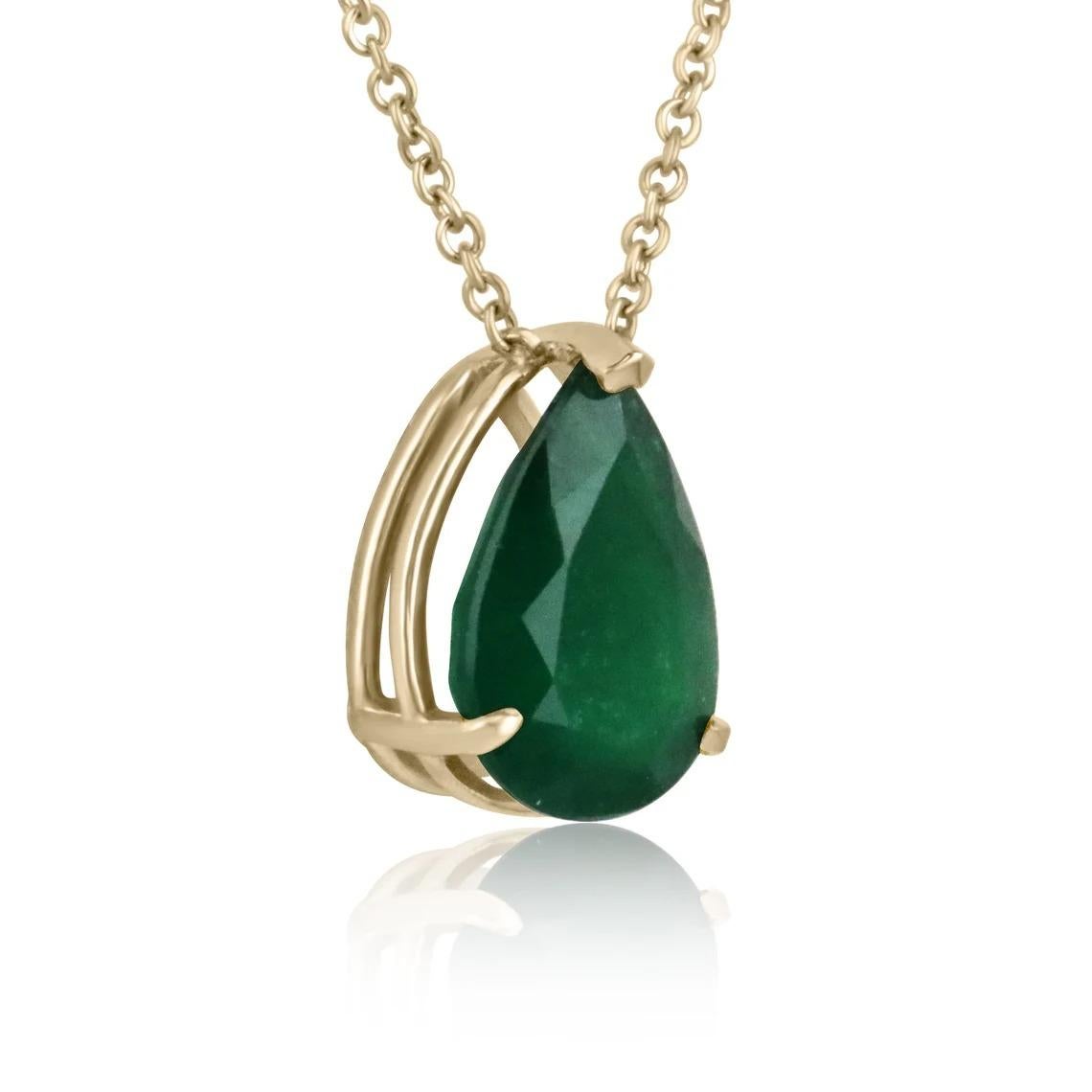 Displayed is a classic Brazillian emerald solitaire necklace set in 14K yellow gold. This gorgeous solitaire ring carries a full 5.74-carat emerald in a three-prong setting. Fully faceted, this gemstone showcases excellent shine. The emerald has