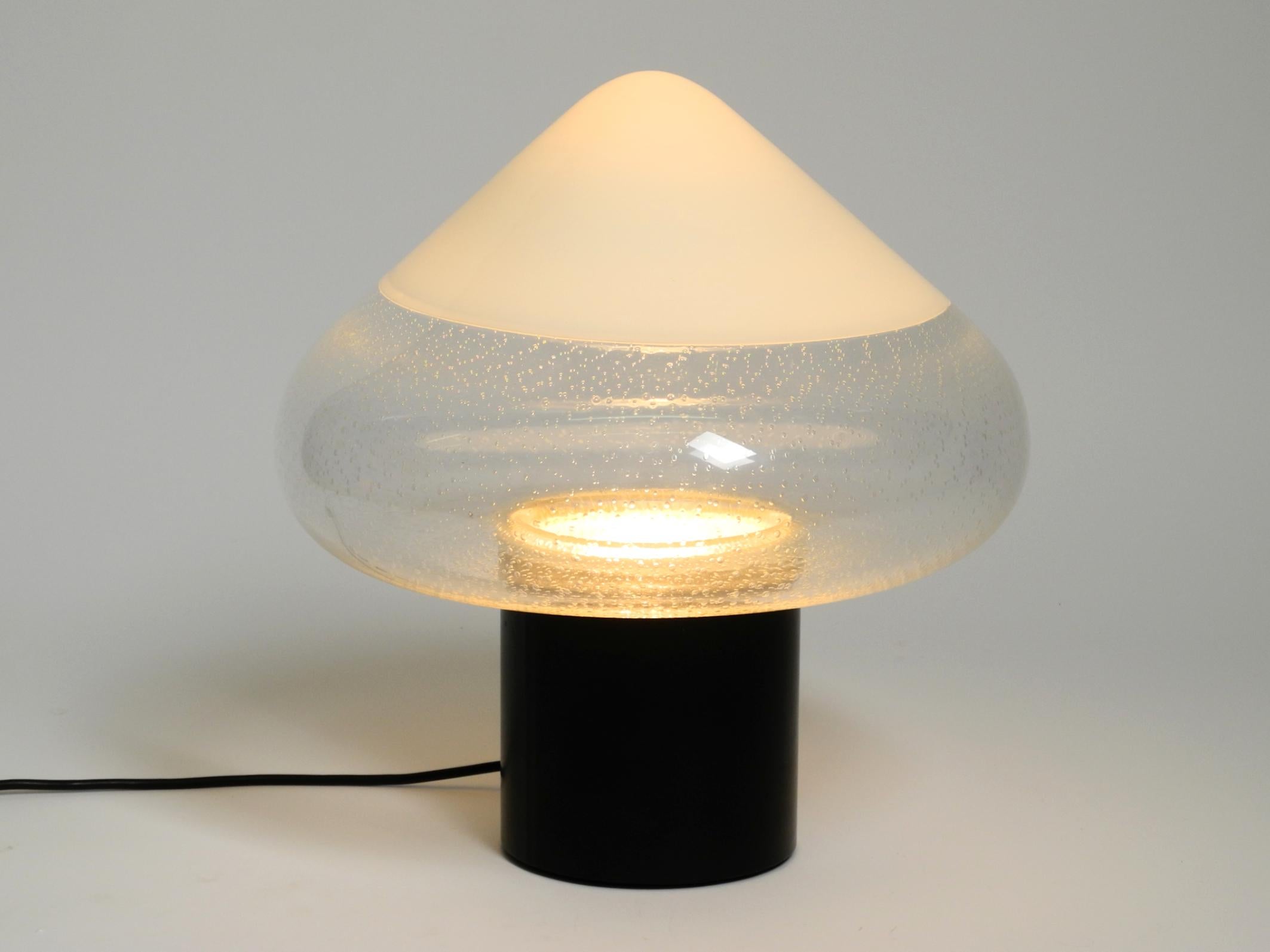 Gran lámpara de sobremesa de cristal de Murano de dos piezas de los años sesenta.
Diseñado por Roberto Pamio. Fabricado por Leucos. Fabricado en Italia.
Diseño italiano de alta calidad de la Era Espacial.
La pantalla es de cristal de Murano Pulegoso