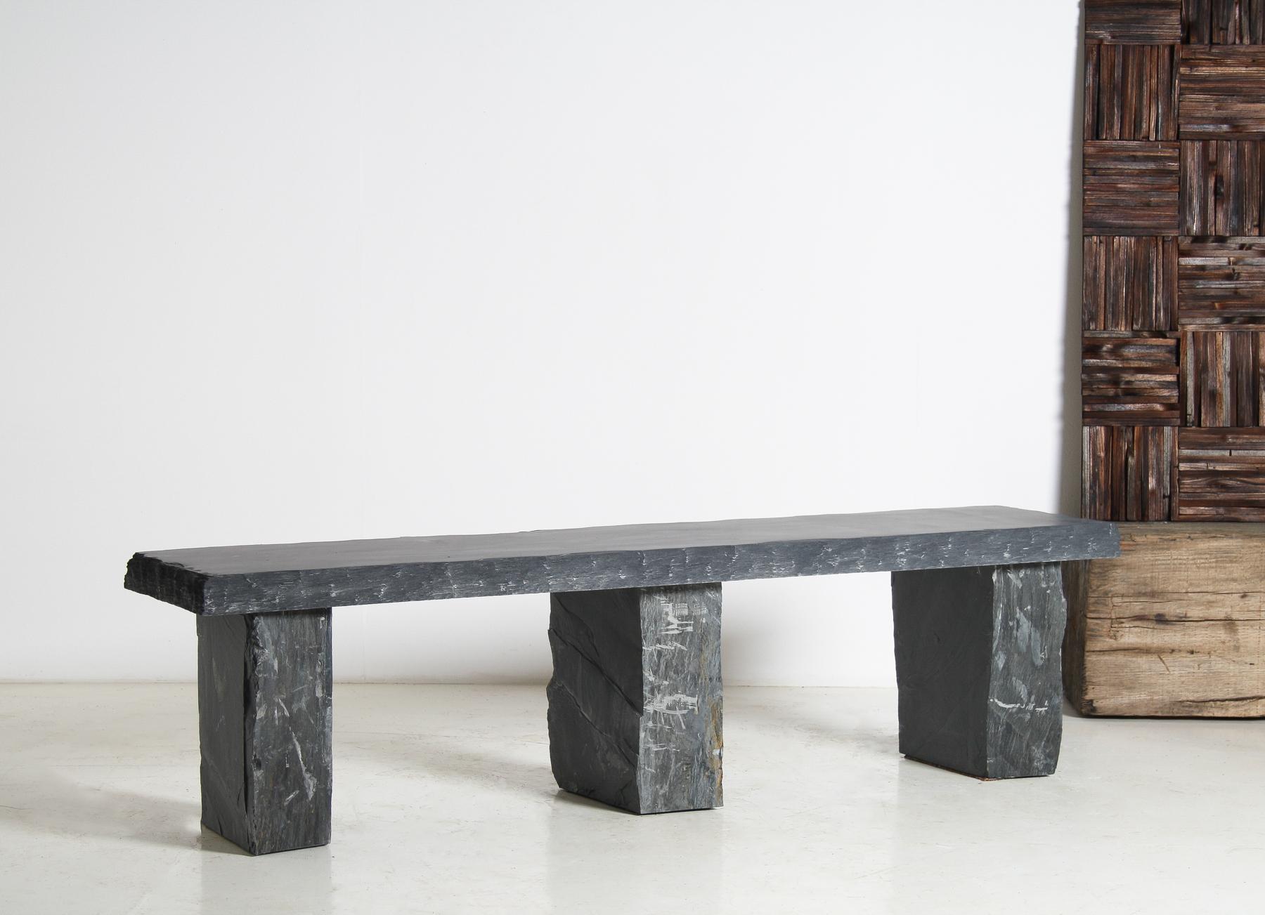 An exceptional 6ft solid stone slate bench, meticulously handcrafted for discerning interior and garden designers. This remarkable piece features a long, honed surface with a beautifully smooth finish, complemented by a contrasting chiselled edge
