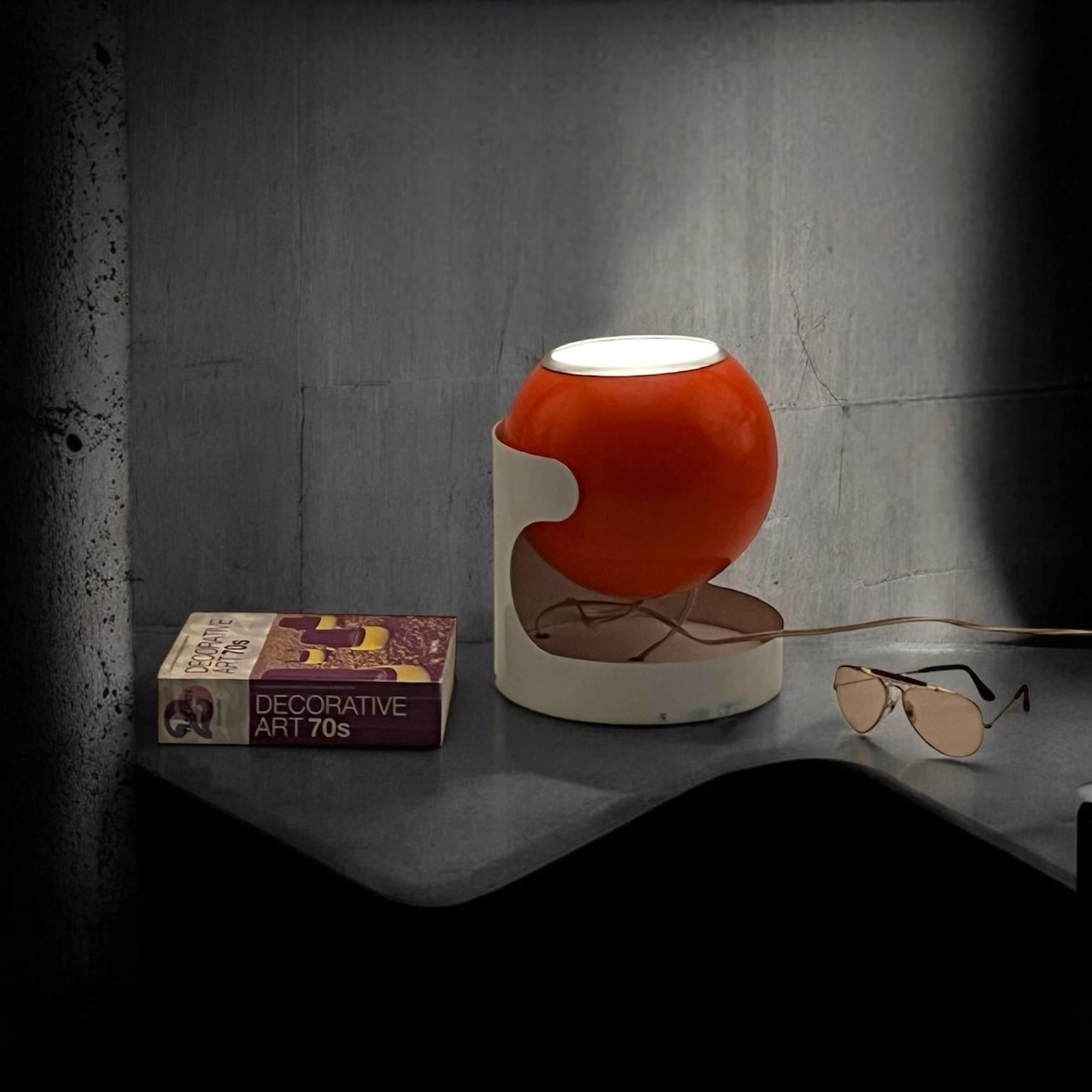Bring bold 70s style into your home with this rare Eyeball Lamp by Luci Milano. Its striking design recalls the iconic KD27 by Joe Colombo for Kartell, offering a standout piece of vintage lighting.

The oversized orange globe contrasts beautifully