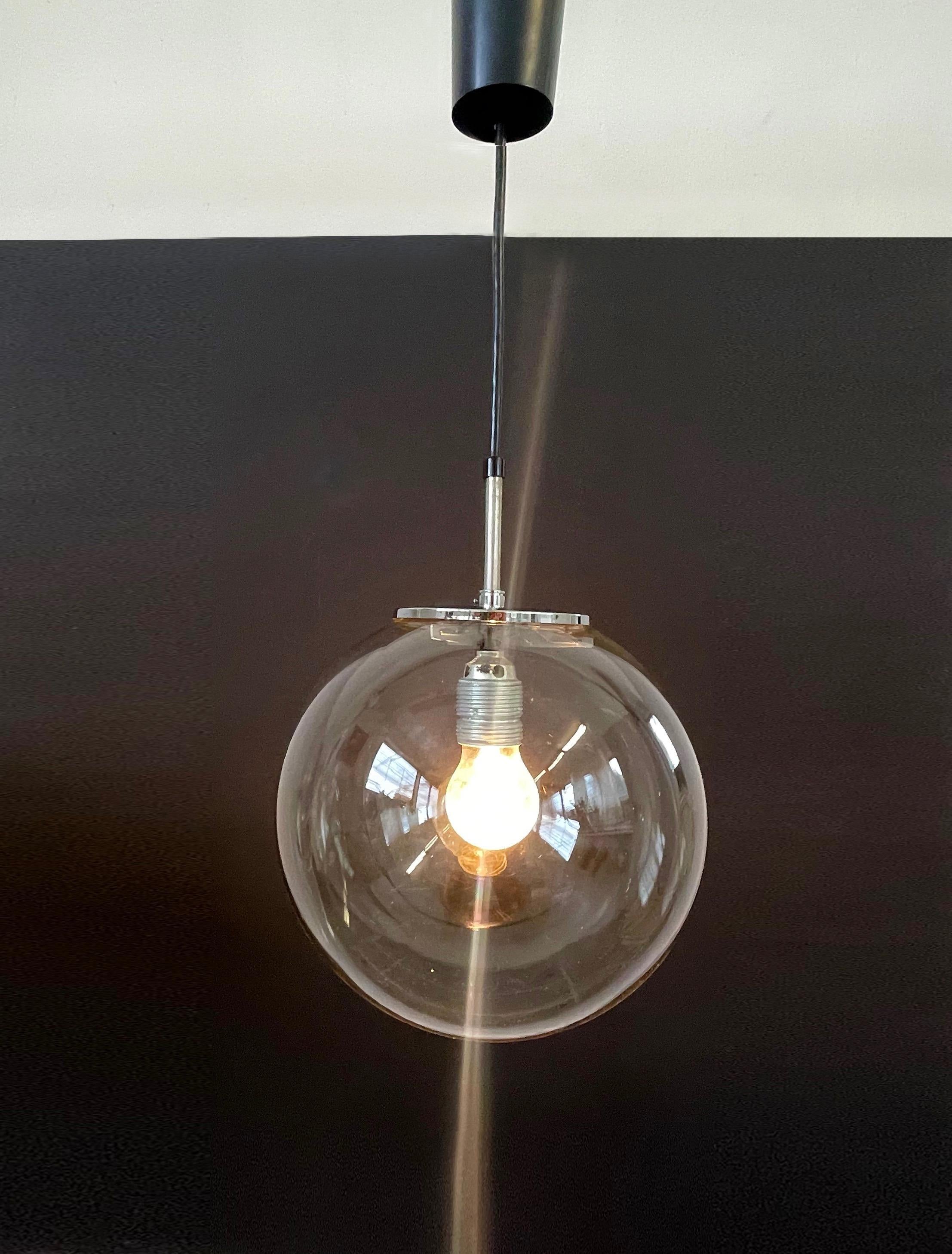 Beautifully designed globe pendant from the German 70s.
Fantastic design very much inspired by the Bauhaus simplicity like Wilhelm Wagenfeld.
Made from hand blown colourless glass and held by a chrome fitting.

A timeless minimalistic piece giving