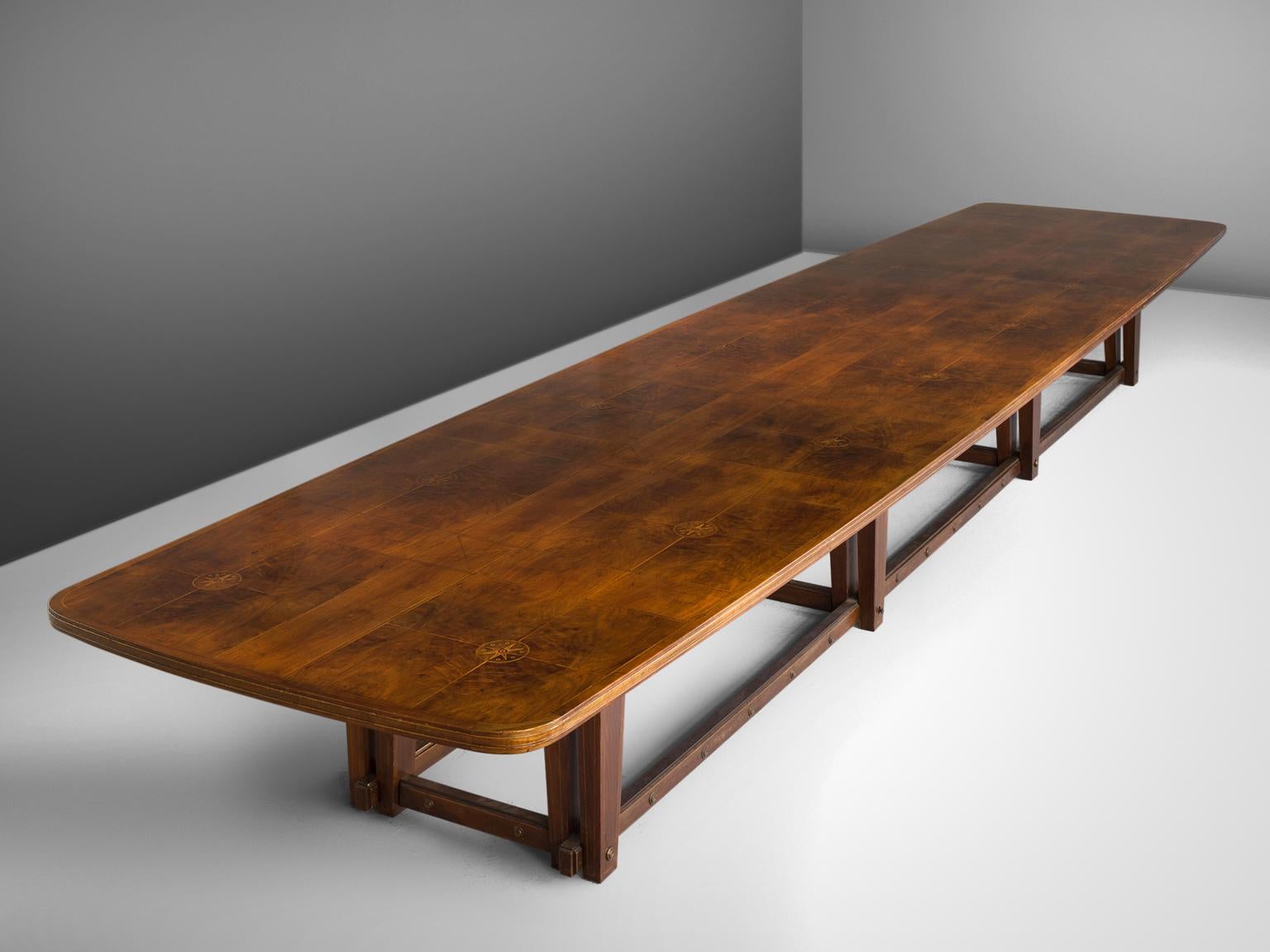 Conference table, in walnut, Europe, 1950s.

Extremely large conference table in walnut. The top show beautiful inlaid wood. A geometric pattern is created due horizontal and vertical lines. Replenished with the illustration of compass-card. The