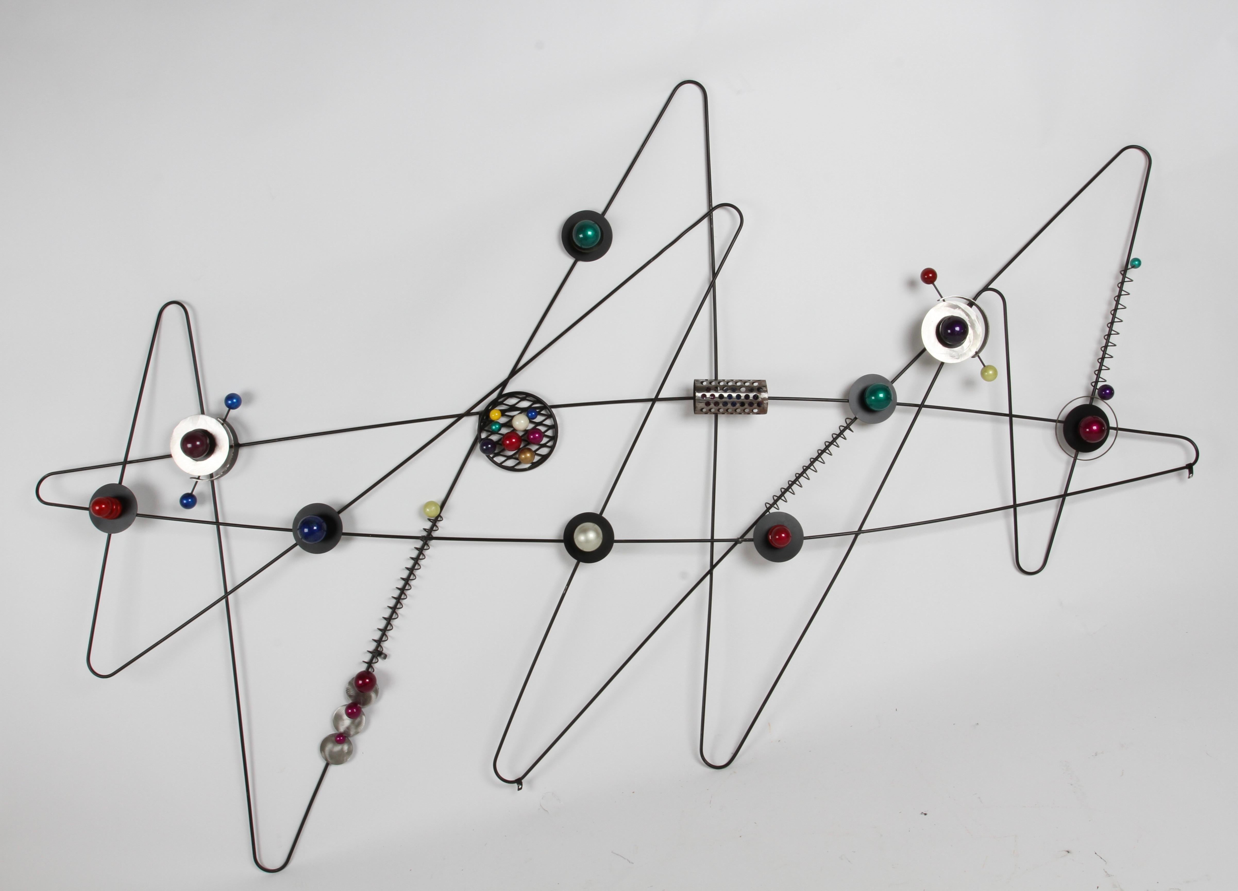 One of a kind Atomic Age large Mid-Century Modern style wall sculpture made of round black painted bent iron rod, in zig-zag form or atom rings with assorted metallic colored orbs (atoms) and brushed steel details. Circa 1980s sculpture is a perfect