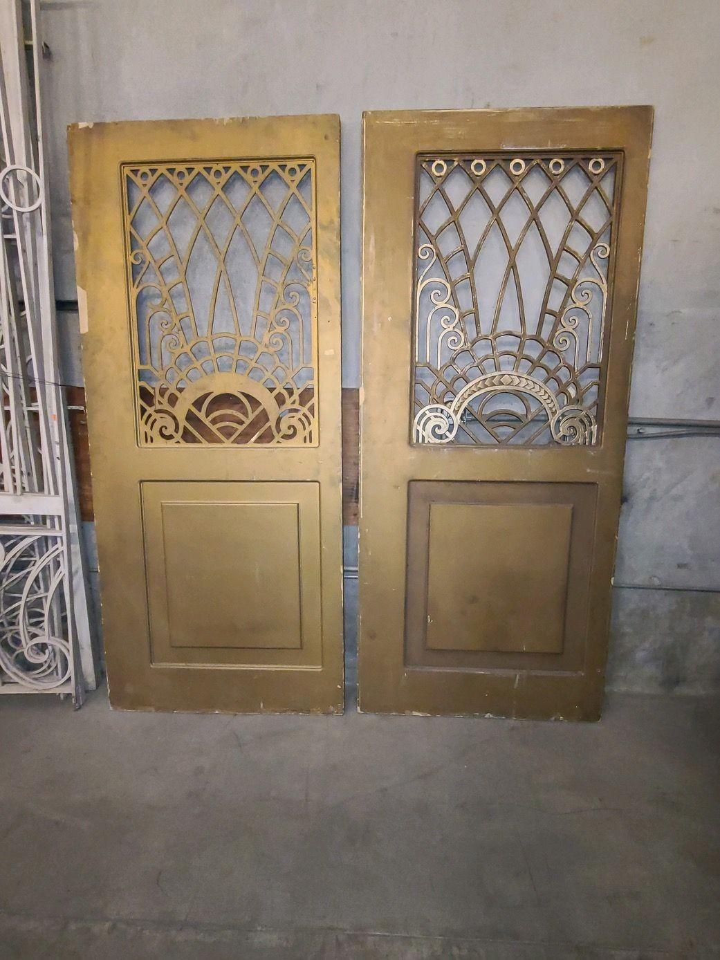 Large 8' multipaneled gold Painted interior double doors featuring multiple crown moldings with geometric Art Deco wrought iron panels along the top. Pulled from a 1920s hotel lobby in Los Angles during the 1970s

Individual Door: H 96