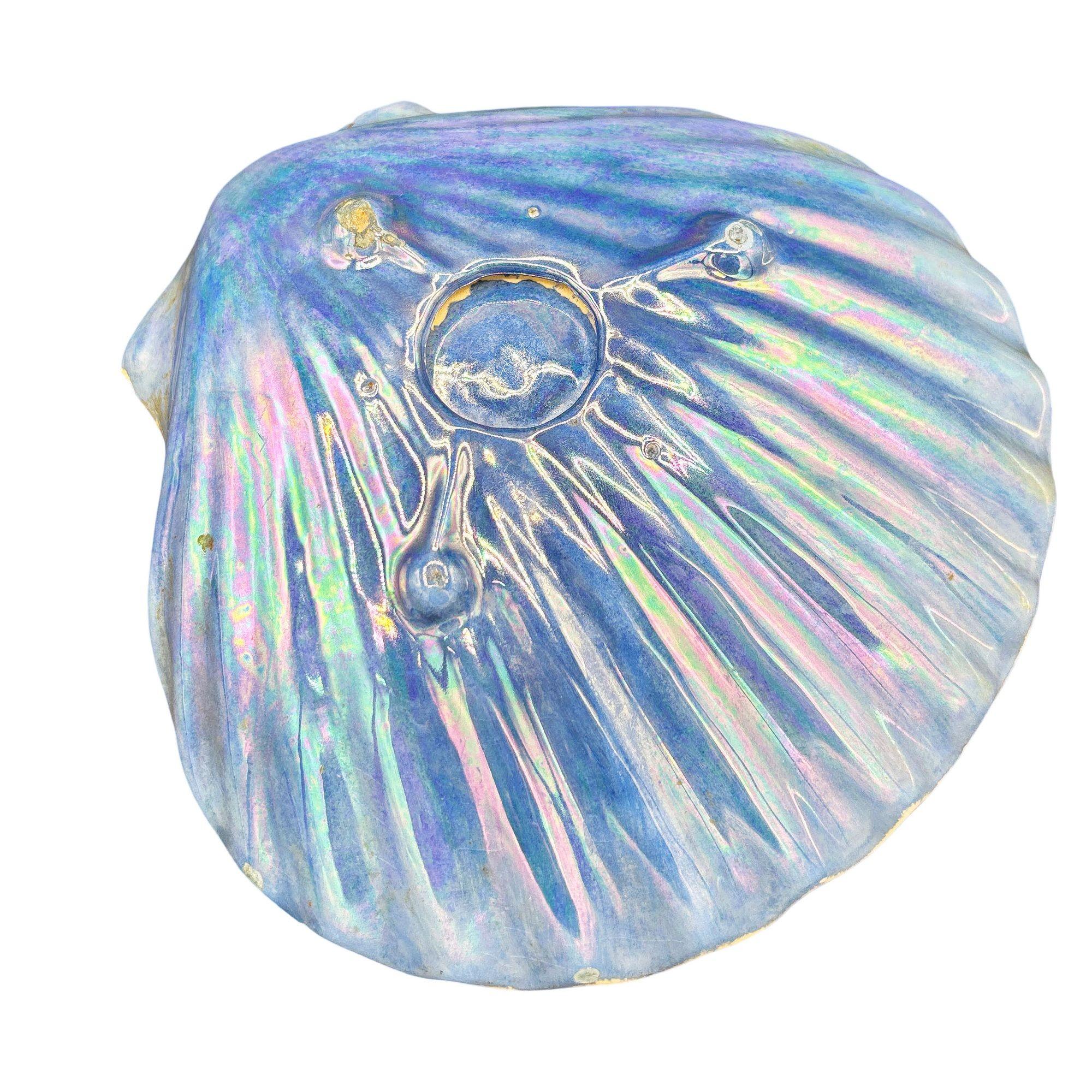 Mid-century rainbow iridescent blue clam shell ceramic ashtray. The ashtray features a calm shell shape with a white gloss finish interior and iridescent blue exterior.

Measurements: 2