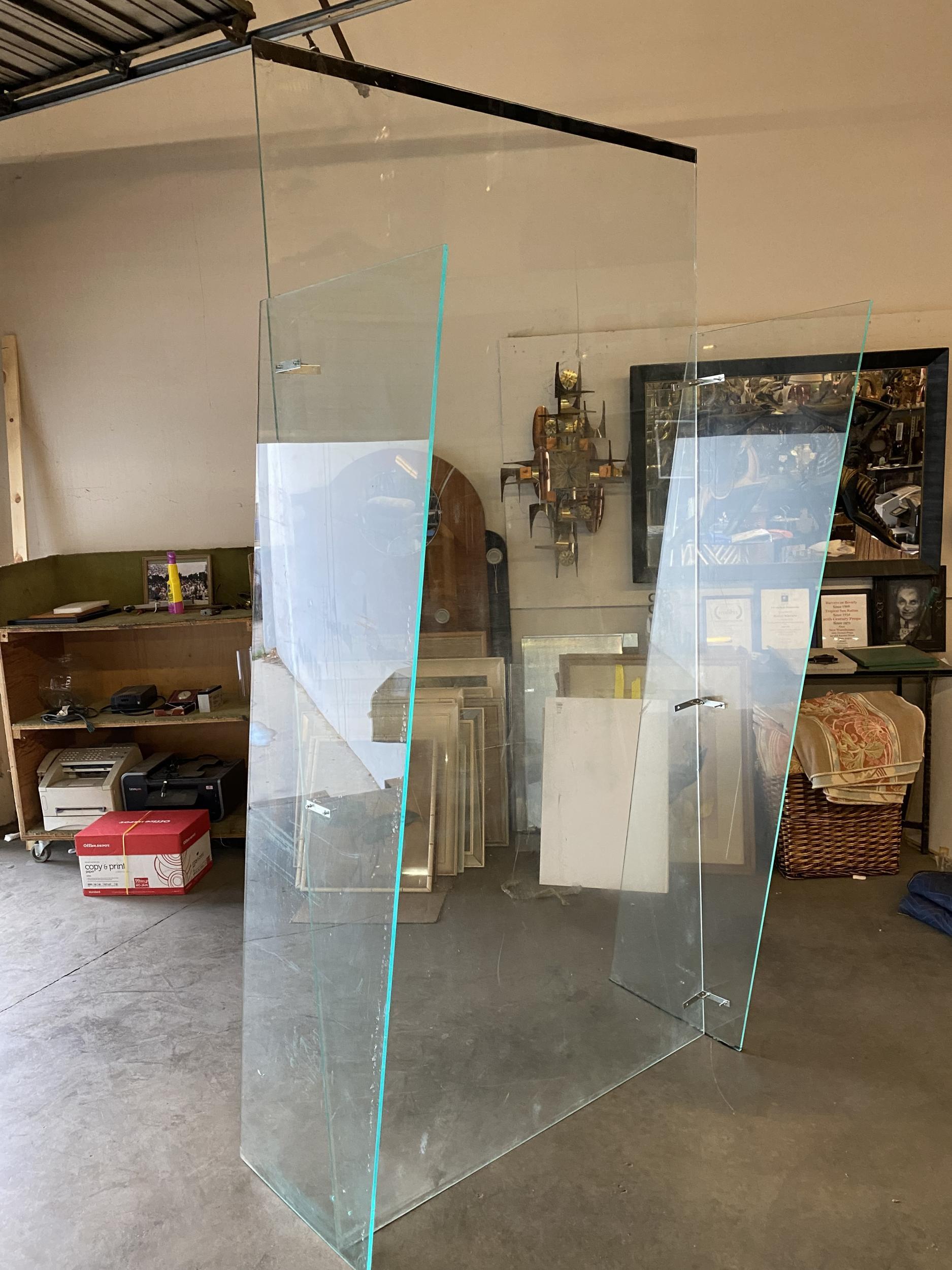 Large 8' tall foot post modern plexiglasss wall divider made of 3 pieces of custom made plexi. There is a directional caution pattern along the top. 
 
 