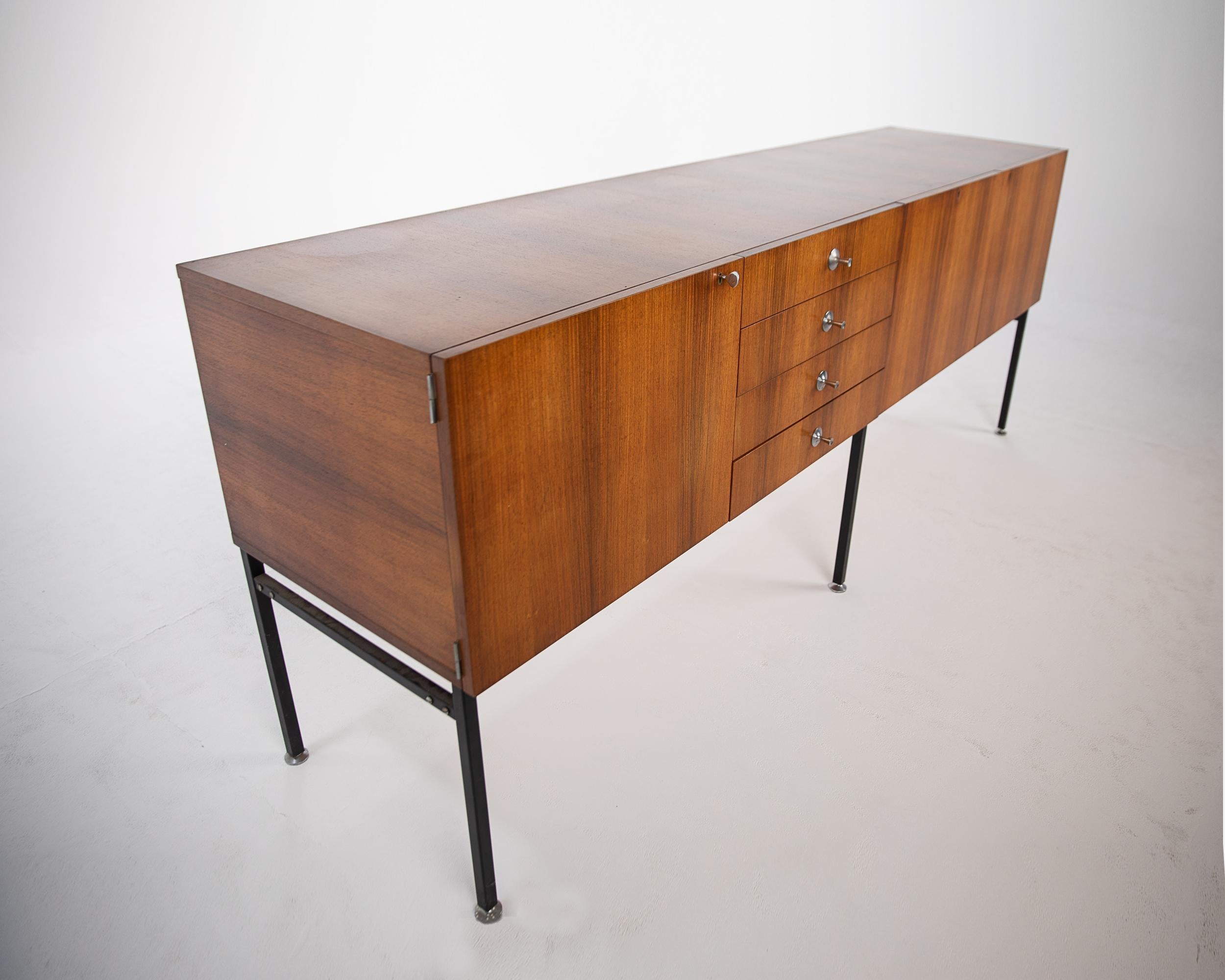 Large sideboard with bar designed in 1958 by French designer Alain Richard for Meubles TV.
Very good quality manufacturing. The body of the buffet, in oak veneer, rests on a black lacquered steel base. The adjustable feet are in chrome steel as are