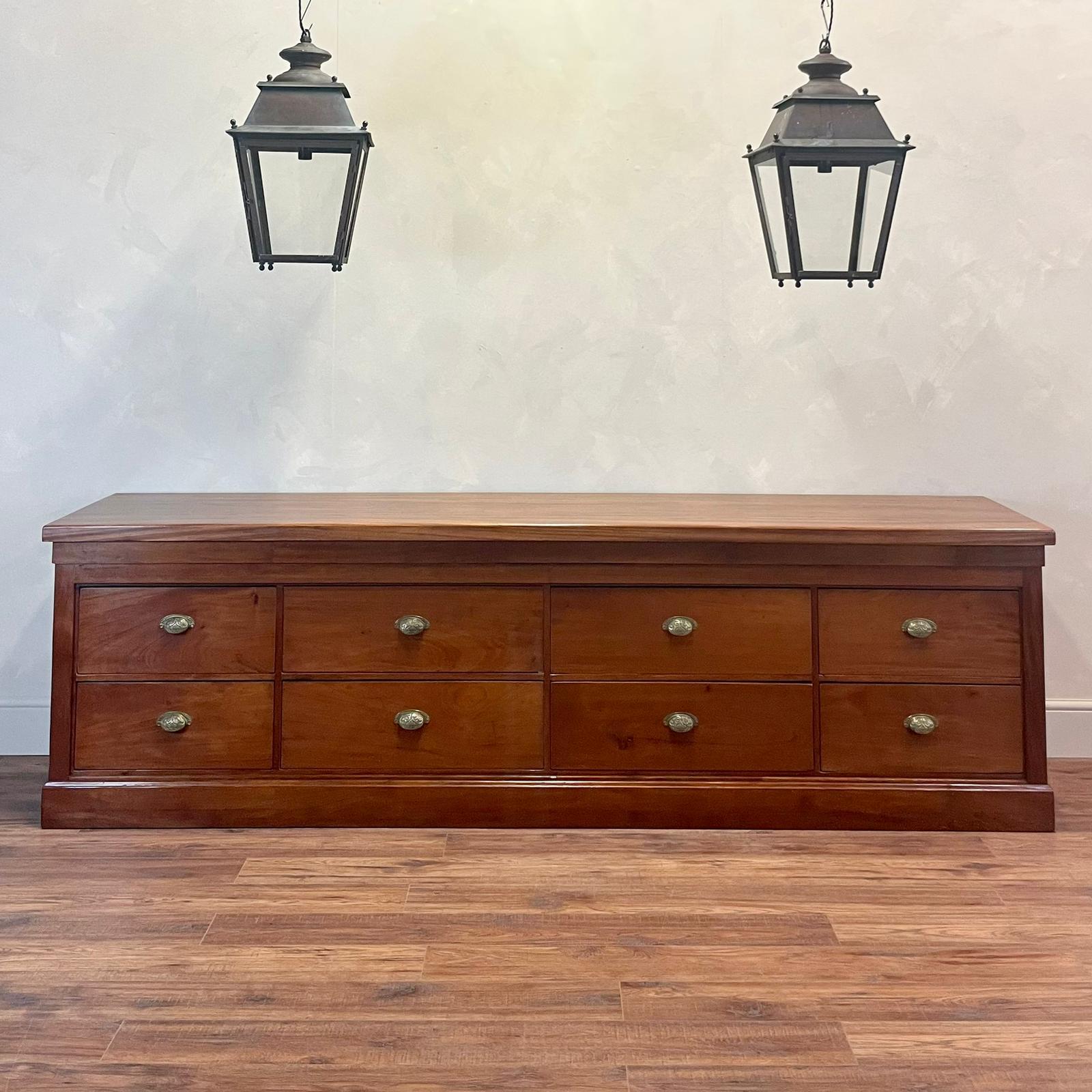 Just under 9 foot, Mahogany bank of eight deep drawers. With original decorative brass cup handles. Super quality. England, circa 1910. 

This could be used as a console , in a Bedroom or a Kitchen 
This piece has been lovingly restored taking