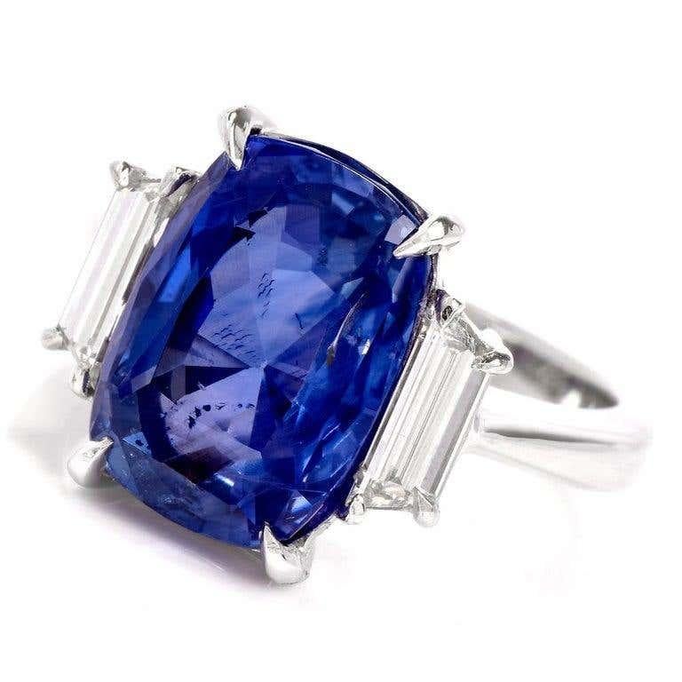 This NEW  high-quality three stone sapphire and diamond ring is crafted in solid platinum. 
Displaying a prominent cushion-cut   natural No Heat genuine blue sapphire with GIA lab report weighing approx. 9.07 carats and measuring 13.28 x 9.41 x