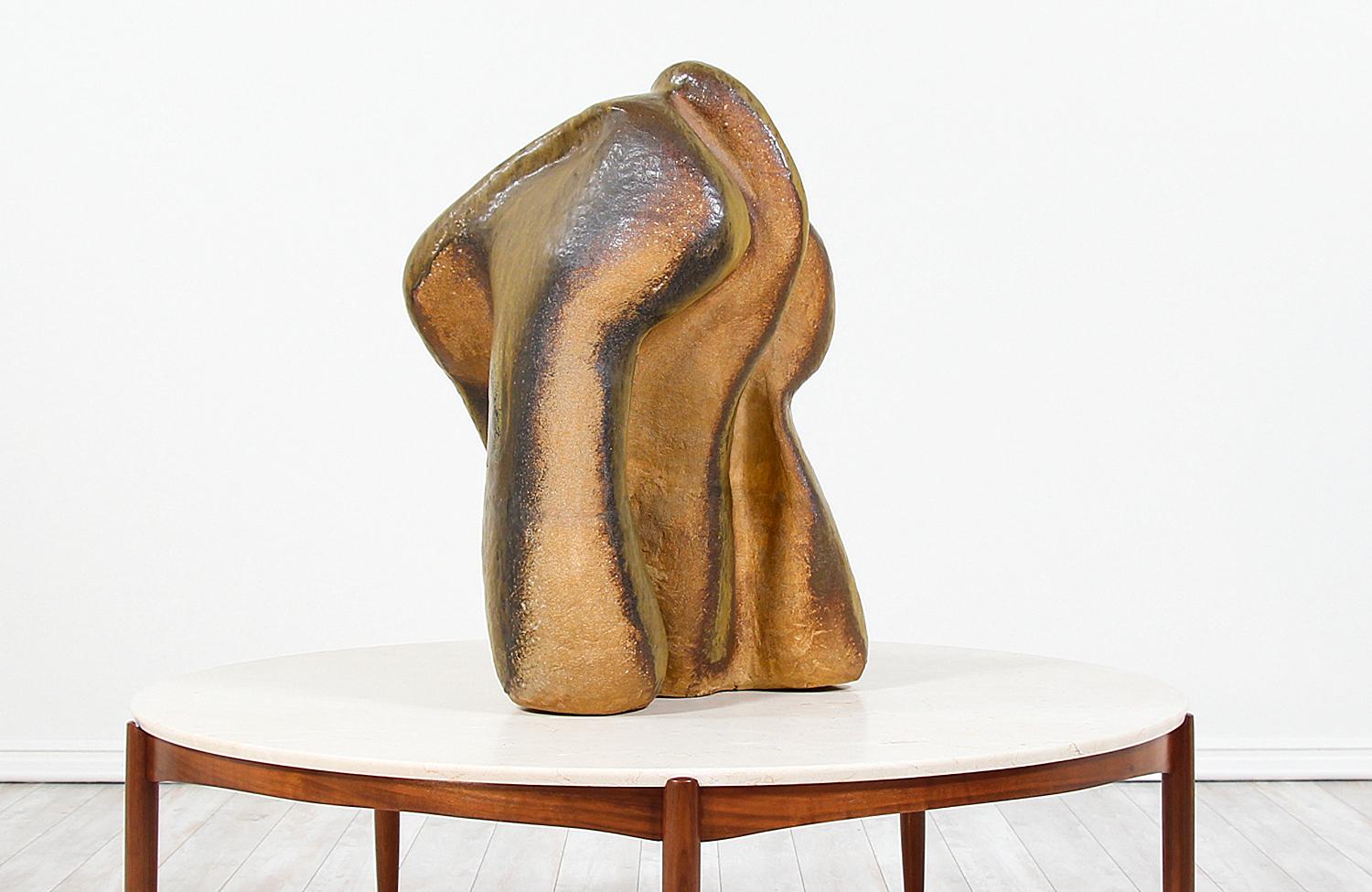 Modern abstract ceramic sculpture designed and manufactured in the United States, circa 1960s. This large sculpture is made of glazed ceramic showing earthy tones and organic forms, creating a unique asymmetrical shape. The surface shows a grainy