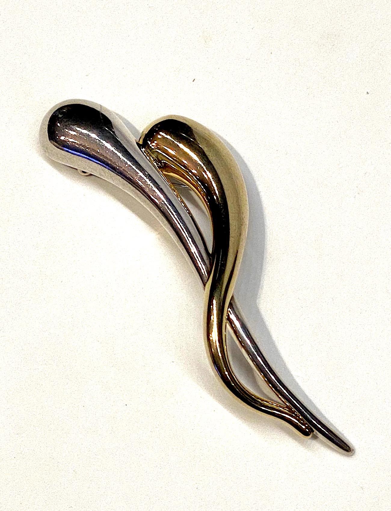 A last artist made brooch in sterling silver with gold plate.  One of the two elongated exclamation shapes is in the natural sterling silver color white the second one is gold plated. The brooch measures 1.63 inches wide, 4.88 inches long and 1 inch