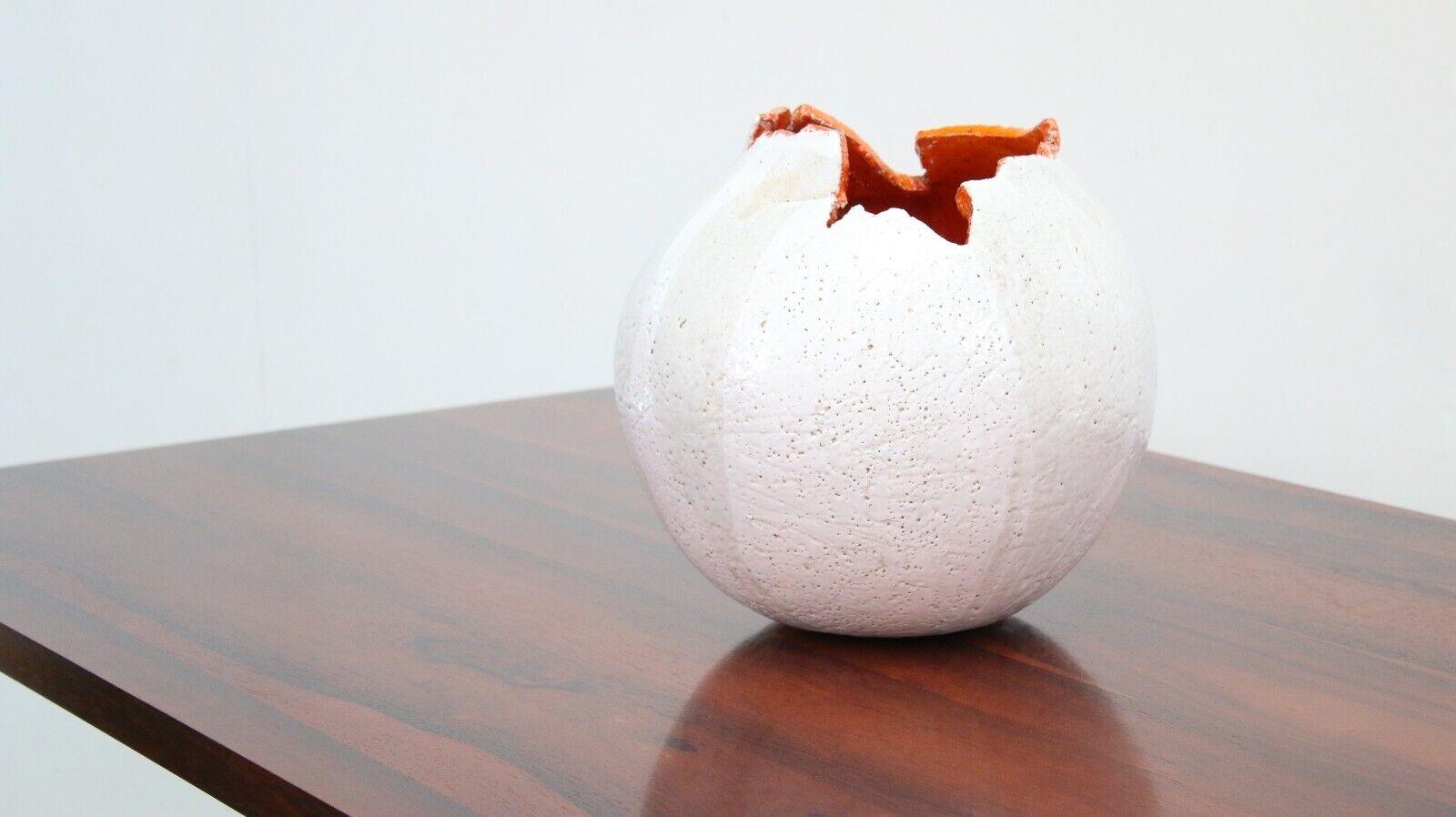Egg-Shaped Display Vase Pot

This vase is an unusual piece of art that makes a great conversation starter. The vase is curved, with an abstract shape and raised detailing. 

It's crafted from white-glazed pottery and has an attractive orange