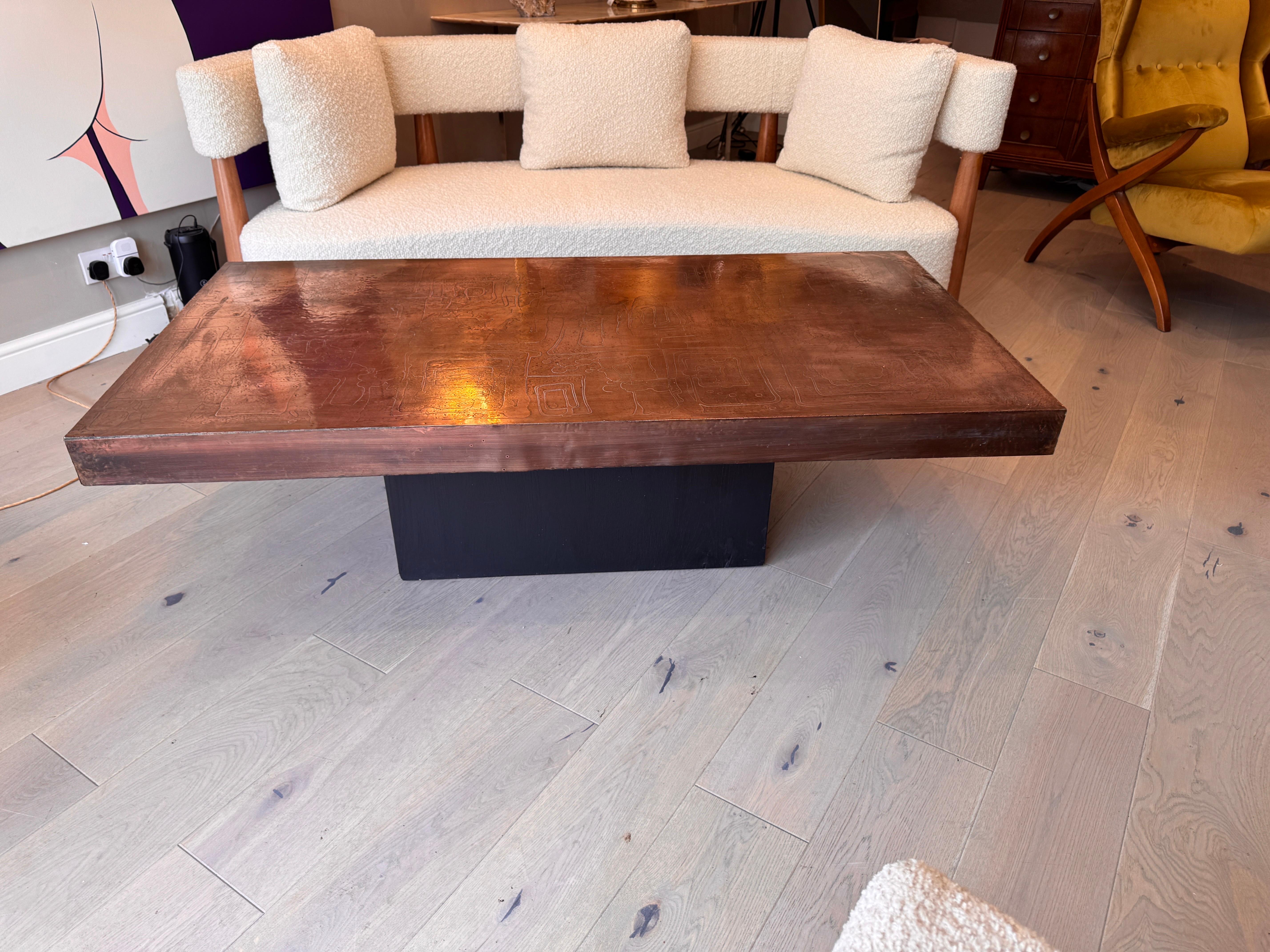 Une grande table basse signée en cuivre gravé à l'acide et oxydé au feu, avec des feuilles de cuivre martelées reposant sur une base rectangulaire en bois foncé C.C.C. Allemagne. 