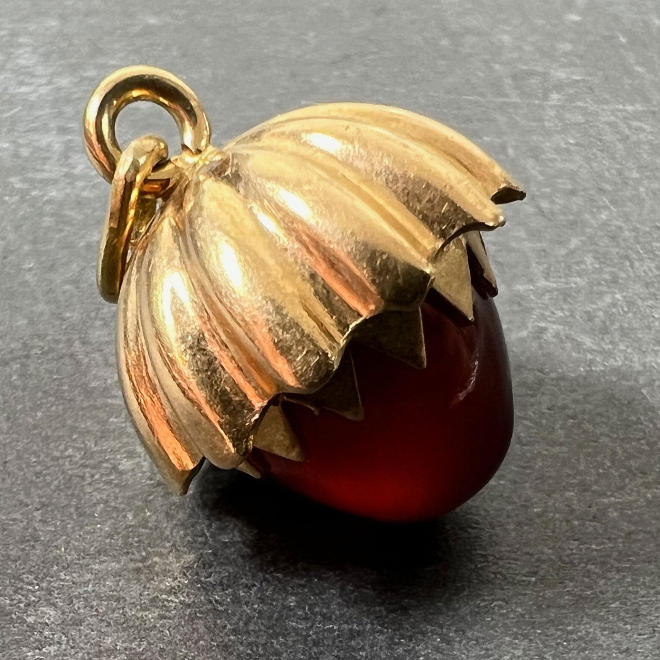 An 18 karat (18K) yellow gold charm pendant designed as an acorn with a carved carnelian (orange chalcedony) nut and ridged gold top. Acorns symbolise fertility, growth, fresh starts and potential. Unmarked but tested for 18 karat gold.

Dimensions: