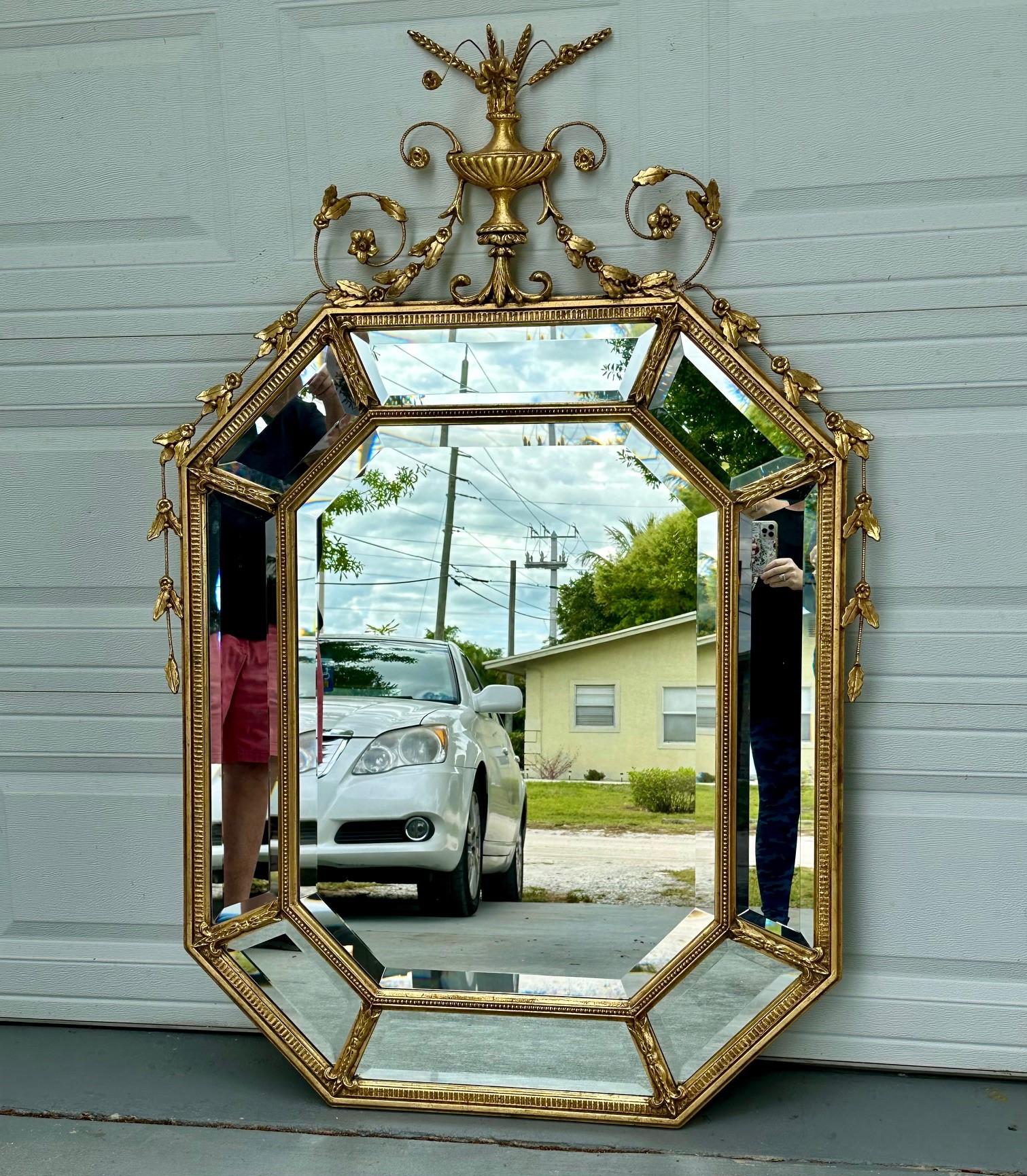Large Adams Style Carved Giltwood Octagonal Wall Mirror.

Glamorous, carved, gilded and beveled octagonal wall mirror. This decorative mirror is made of wood and gesso with an intricate design in the style of Adams. The surround is created with 8